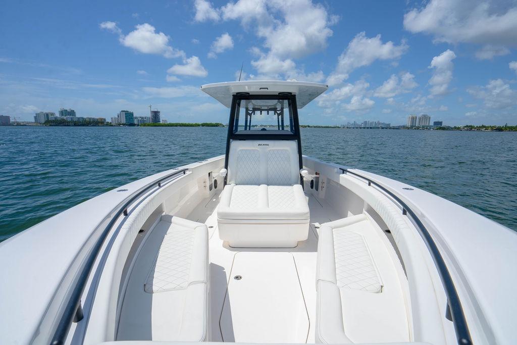 2027 Reef Runner 340 boat on water, featuring sleek white seating and modern design.