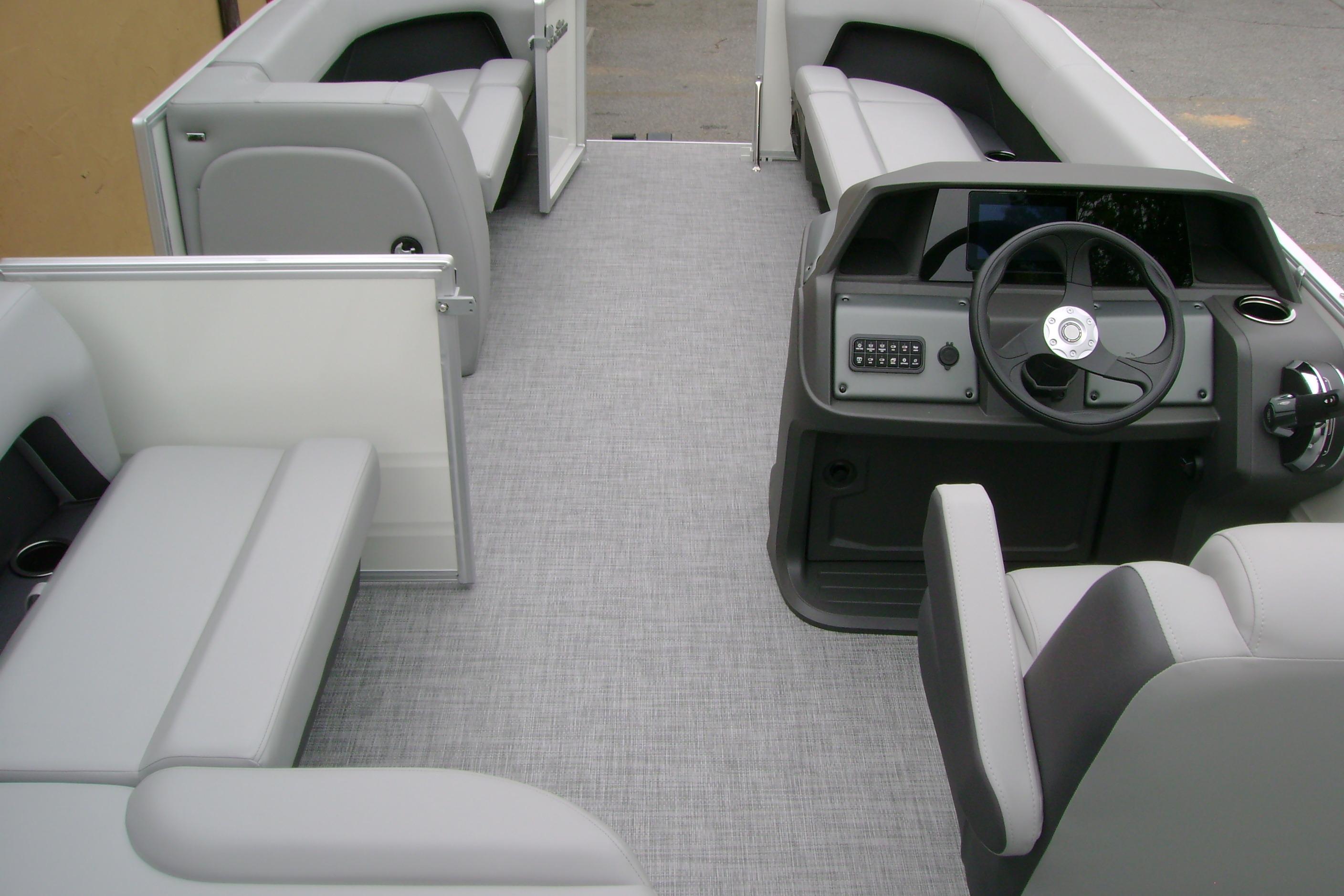 2026 Sun Tracker Party Barge 18 DLX interior with gray seating and steering console.