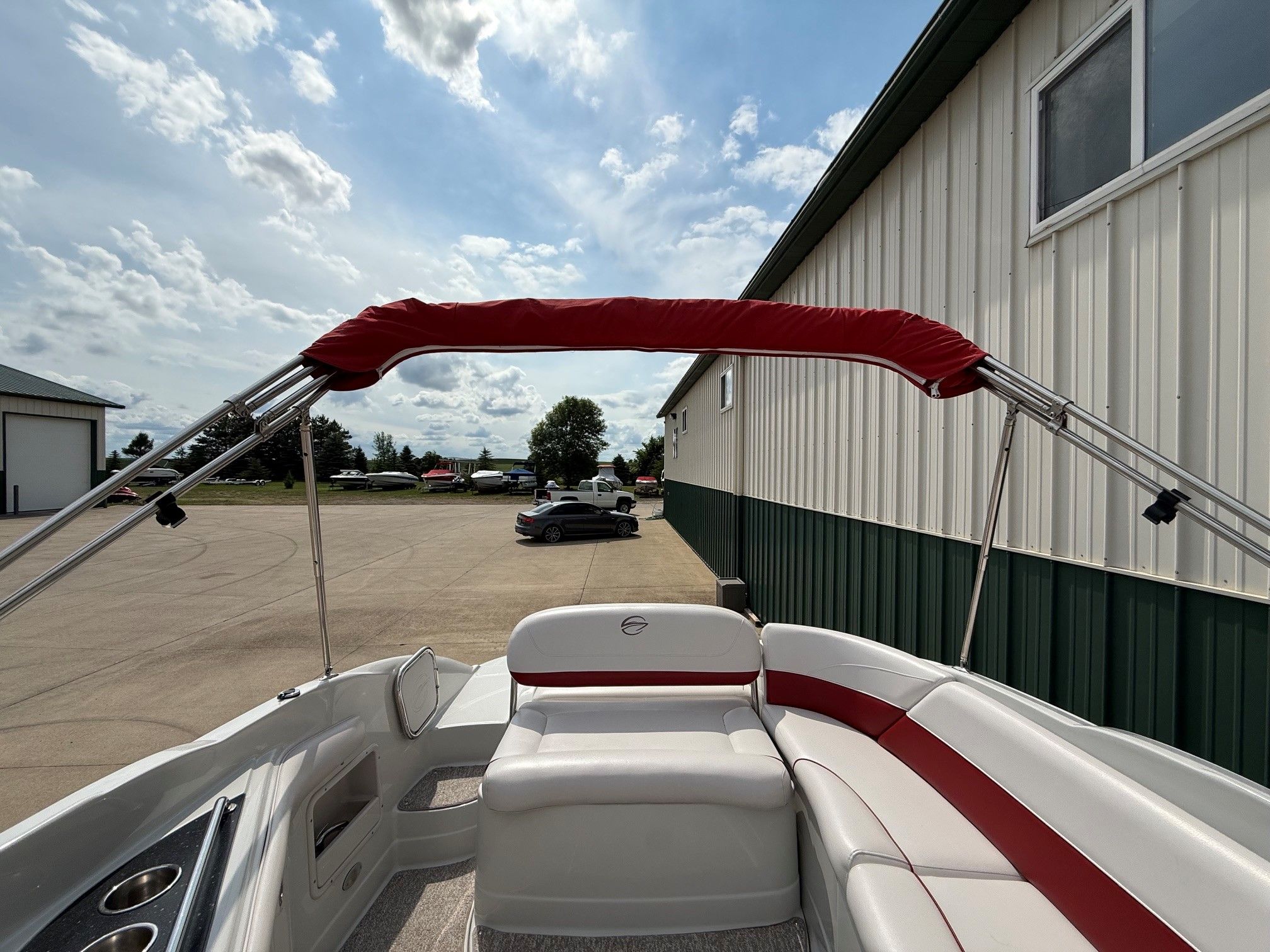 The image shows the cockpit of a Crownline 252 EX boat with red and white seating.