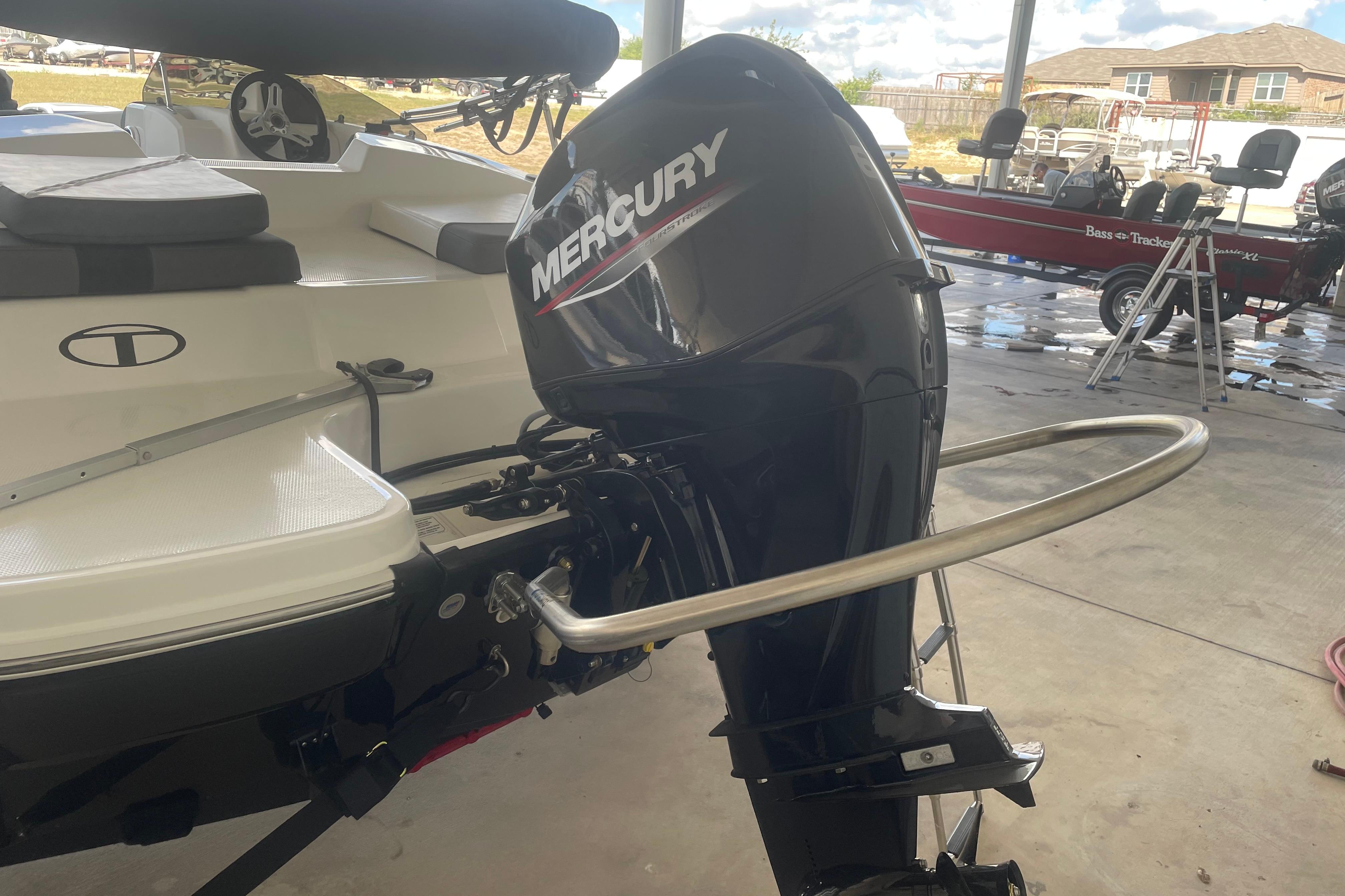 2026 Tahoe T16 boat with Mercury outboard motor in a garage setting.