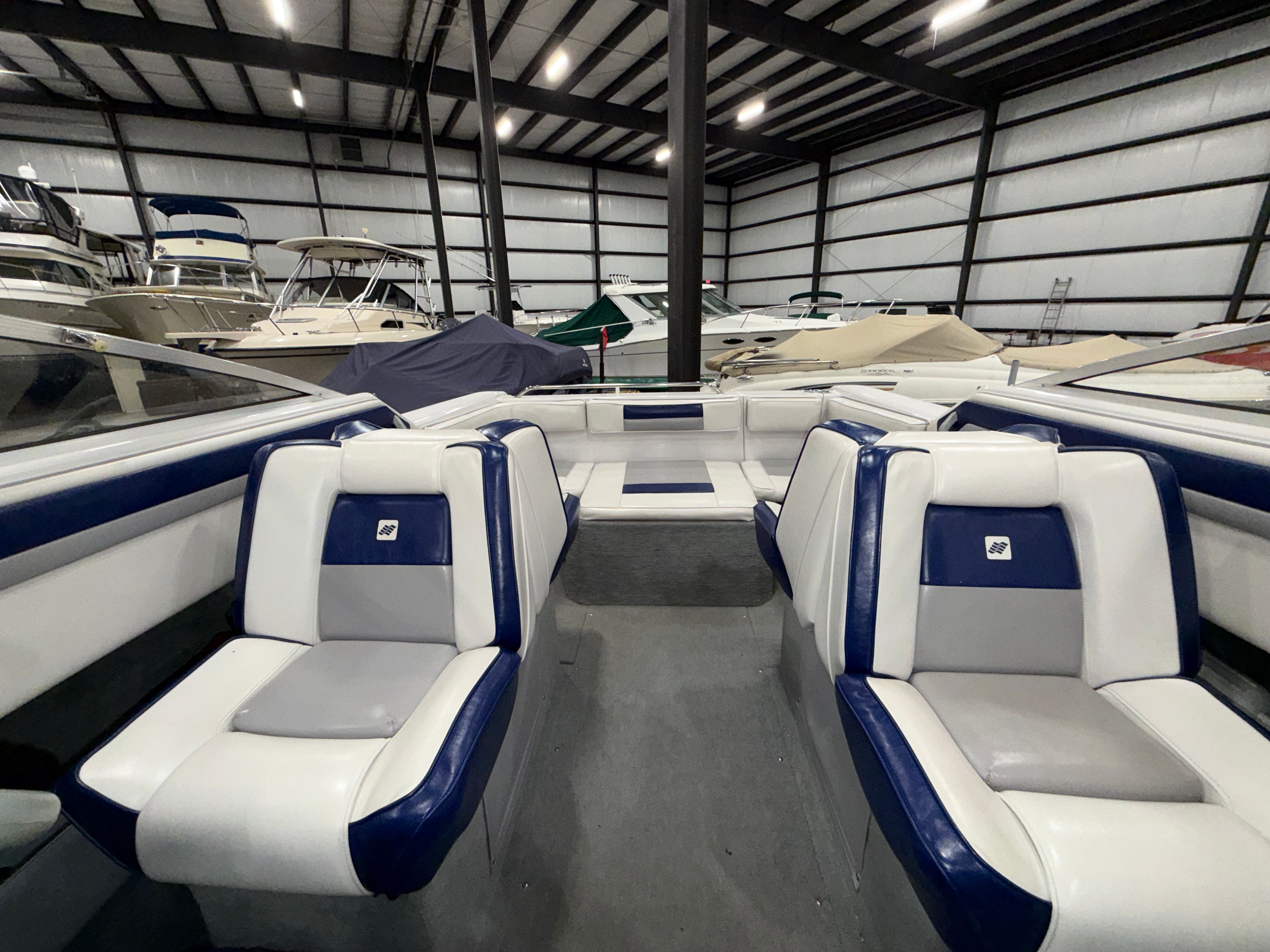 Interior of a 1992 Four Winns 225 Sundowner with blue and gray seating in a storage facility.
