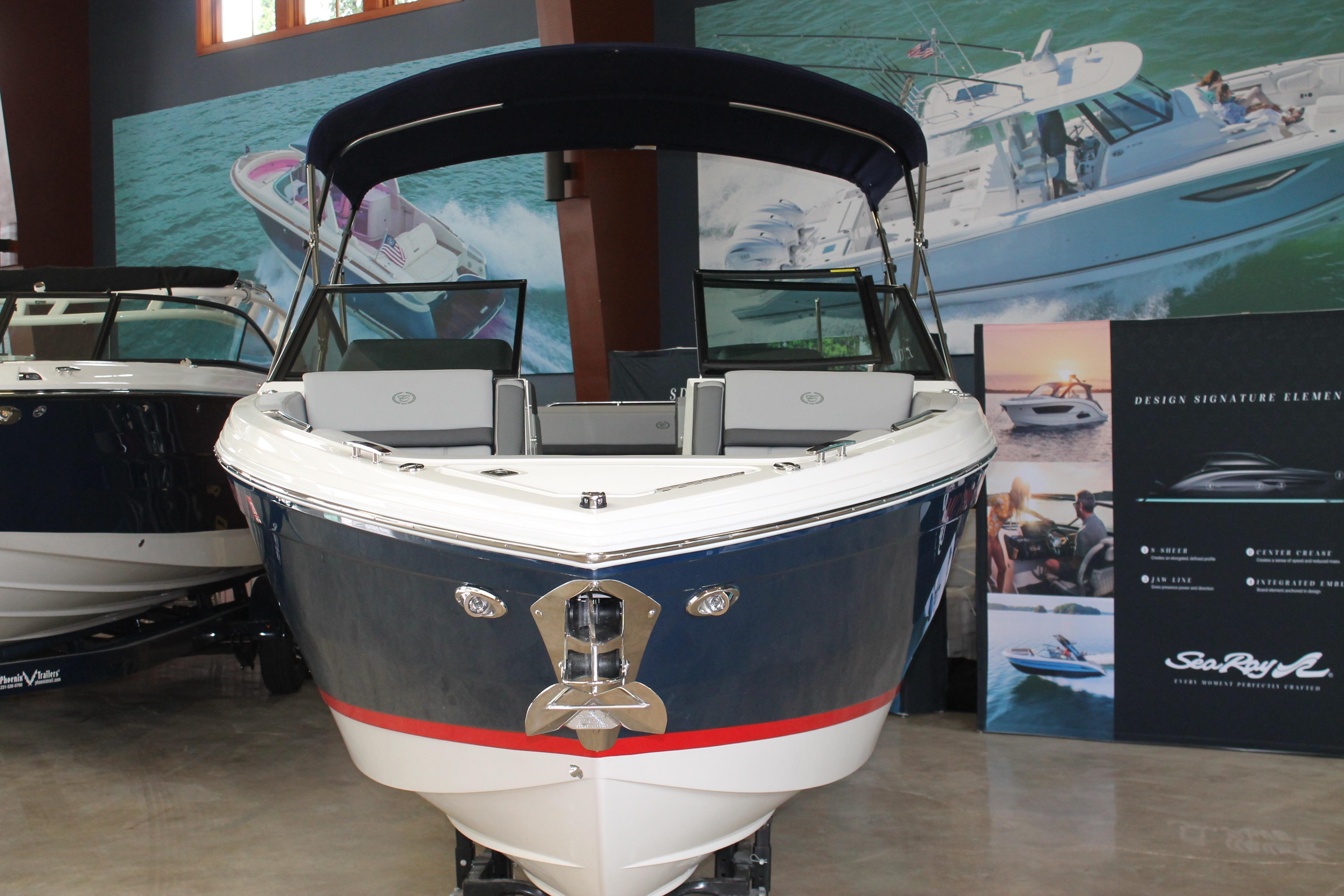 2023 Cobalt R8 boat displayed in showroom with promotional posters.