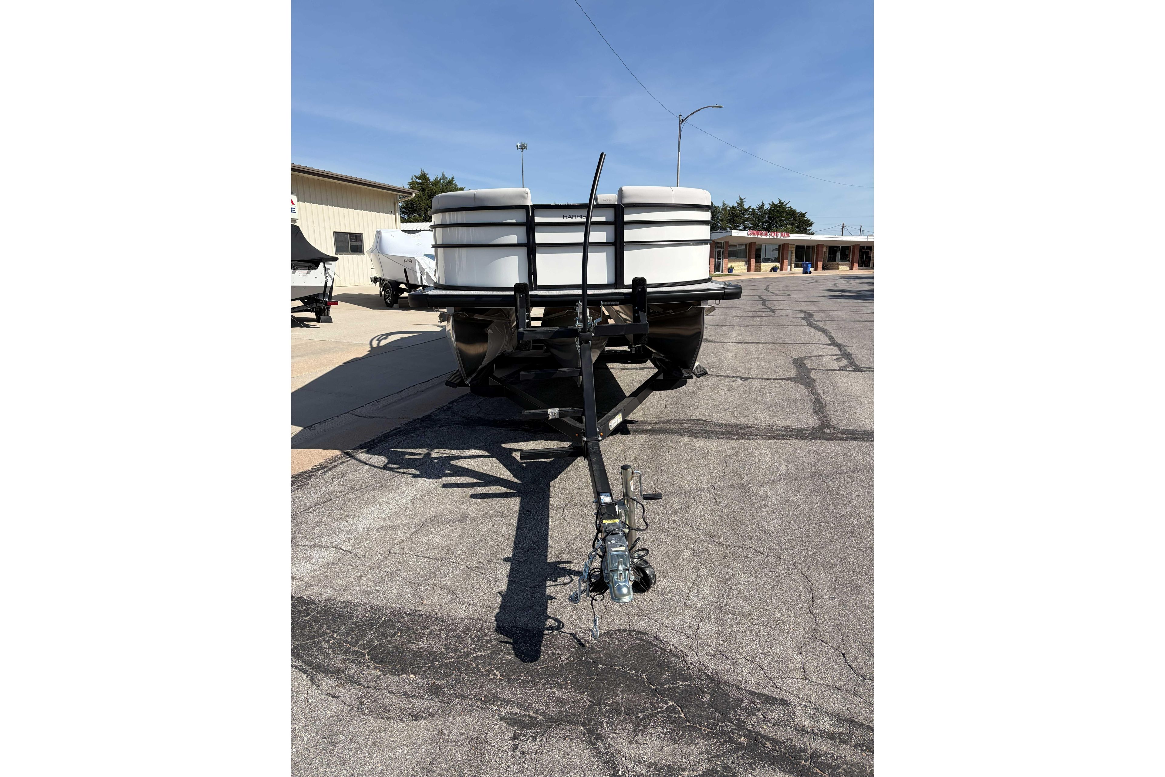 2025 Harris Cruiser 250 pontoon boat on trailer in parking lot.