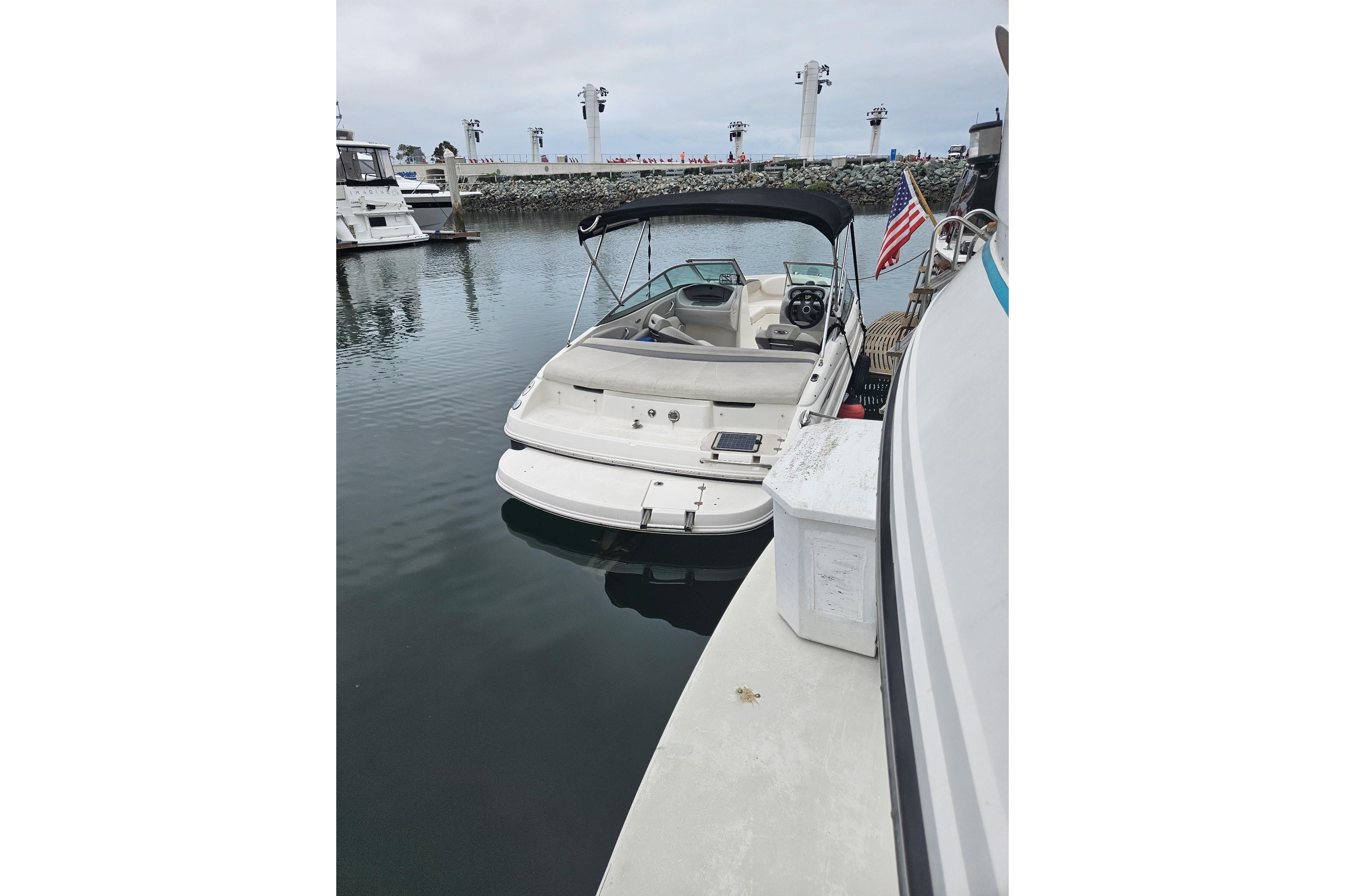 2006 Chaparral 190 SSi boat docked in a marina with American flag.