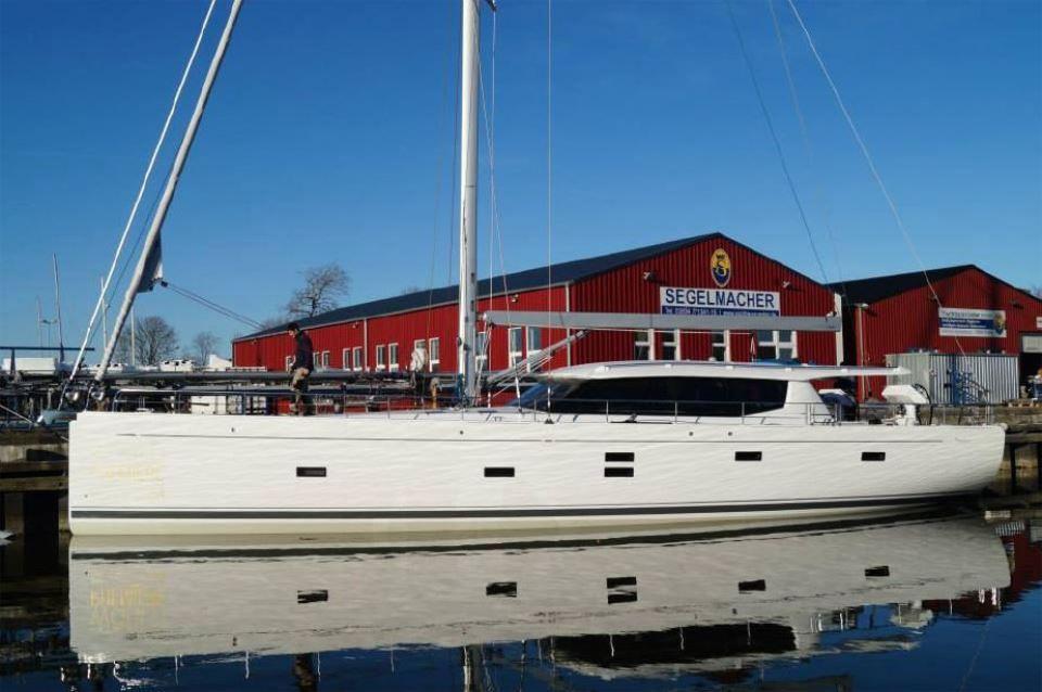 2025 Moody 54 DS yacht docked near red building, clear blue sky.