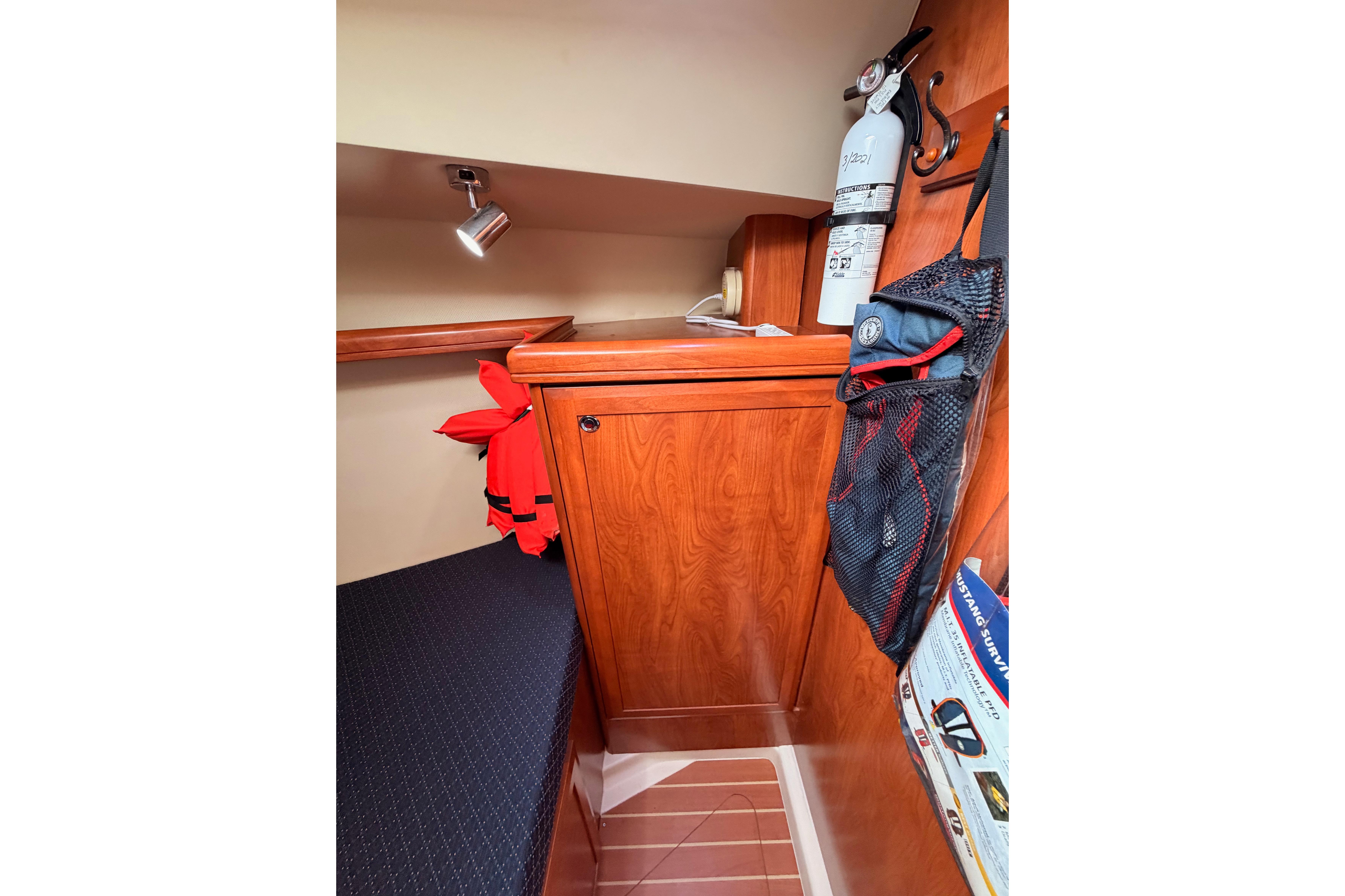 2009 Hunter 38 yacht interior with wooden cabinetry, fire extinguisher, and life jackets.