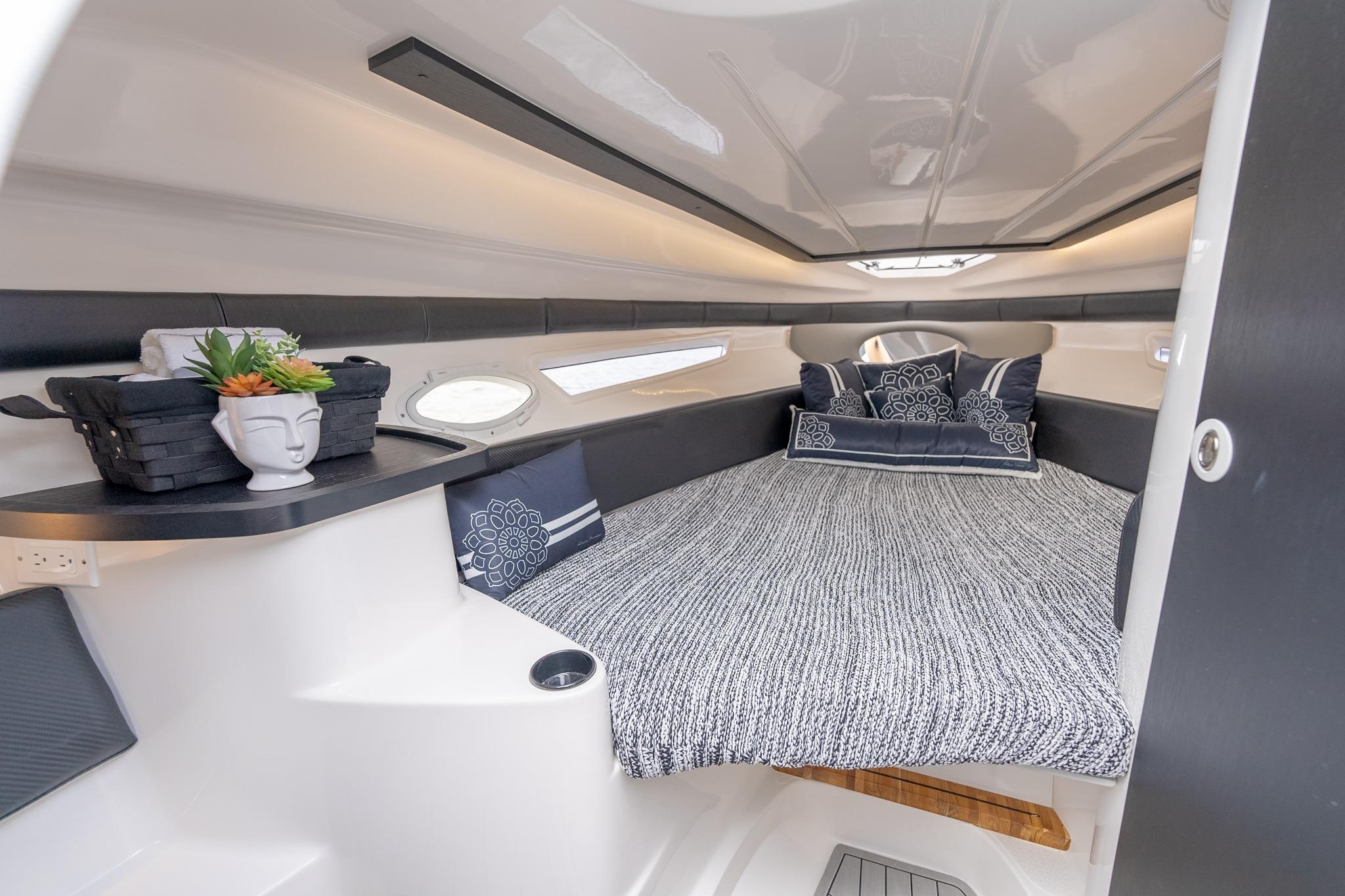 Luxurious interior cabin of 2027 Hanover 305 boat with cozy bedding and stylish decor.