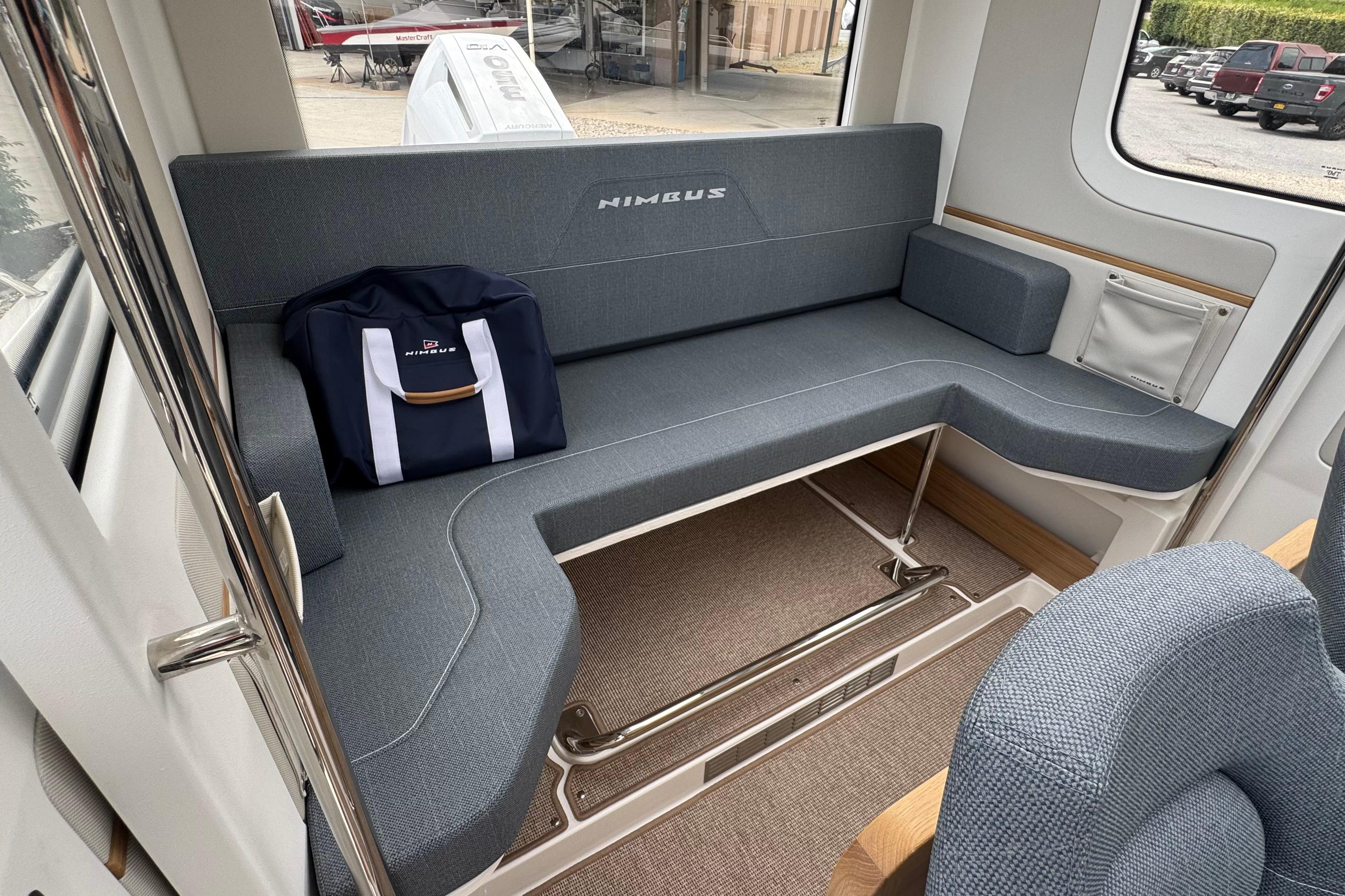 Interior of the Nimbus Commuter 9 with blue upholstery and a bag.