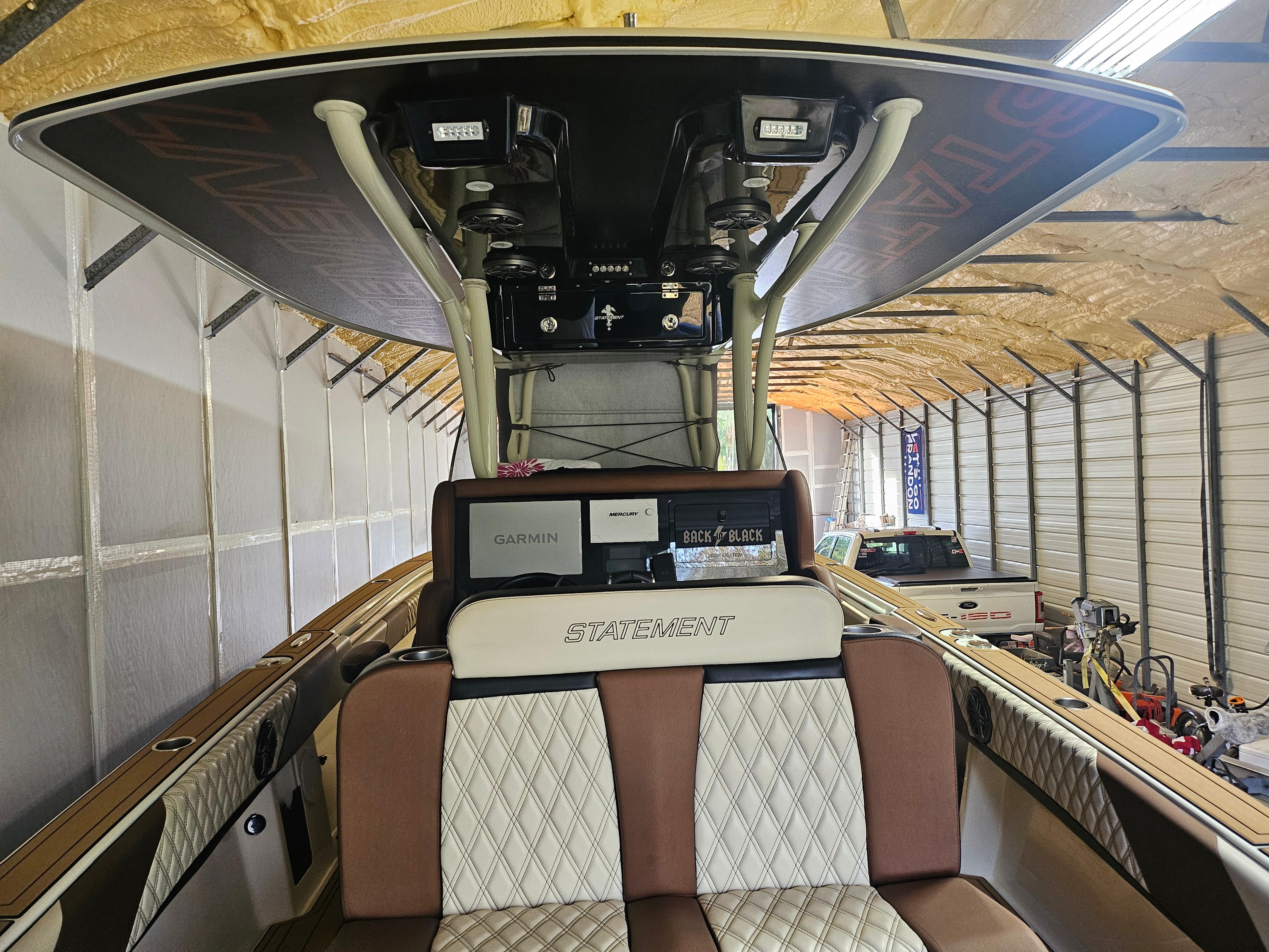 2021 Statement 350 Open boat interior with seating and electronics in a storage facility.