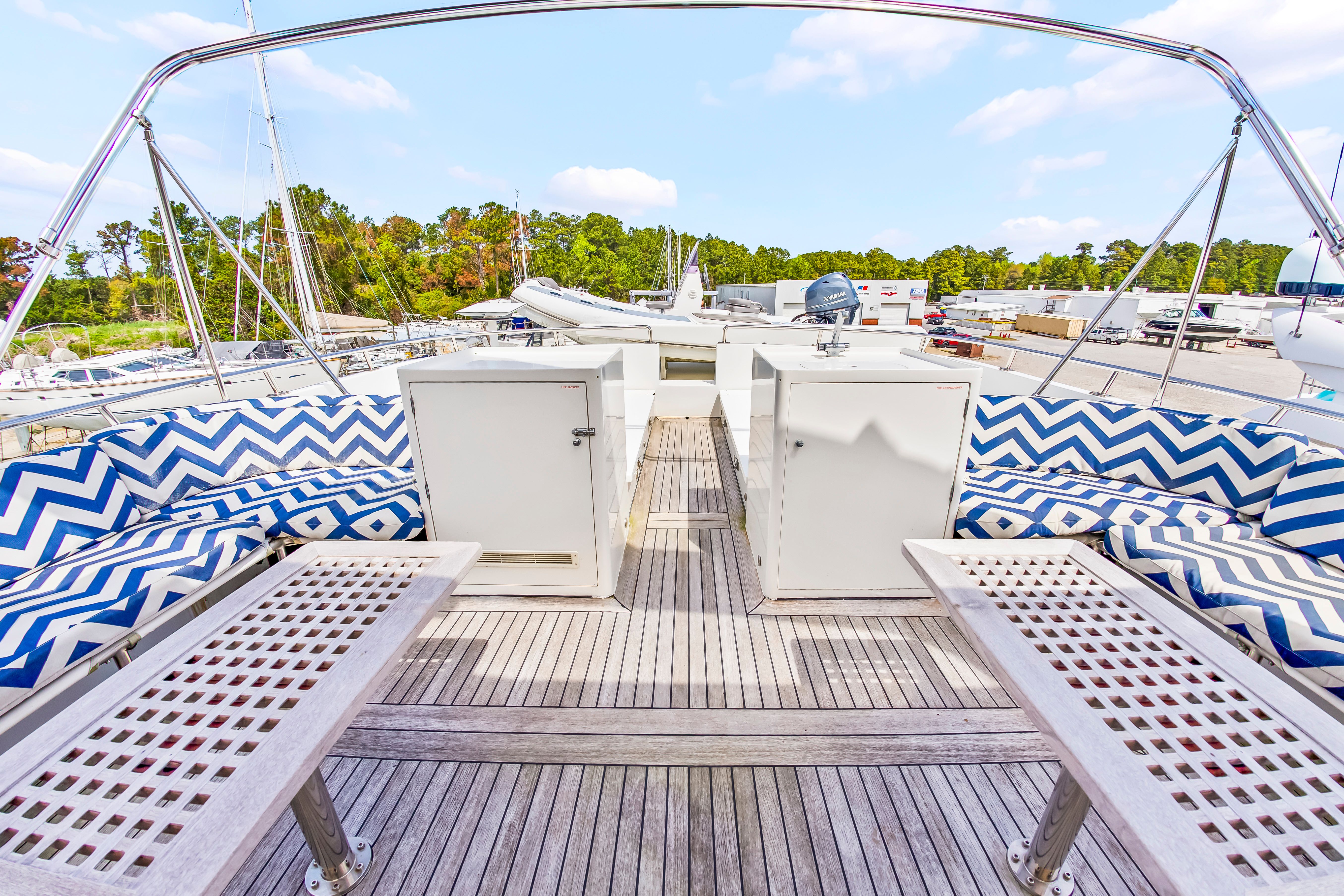 The deck of a 1987 Jongert 78 Motor Yacht with striped cushions and wooden flooring.