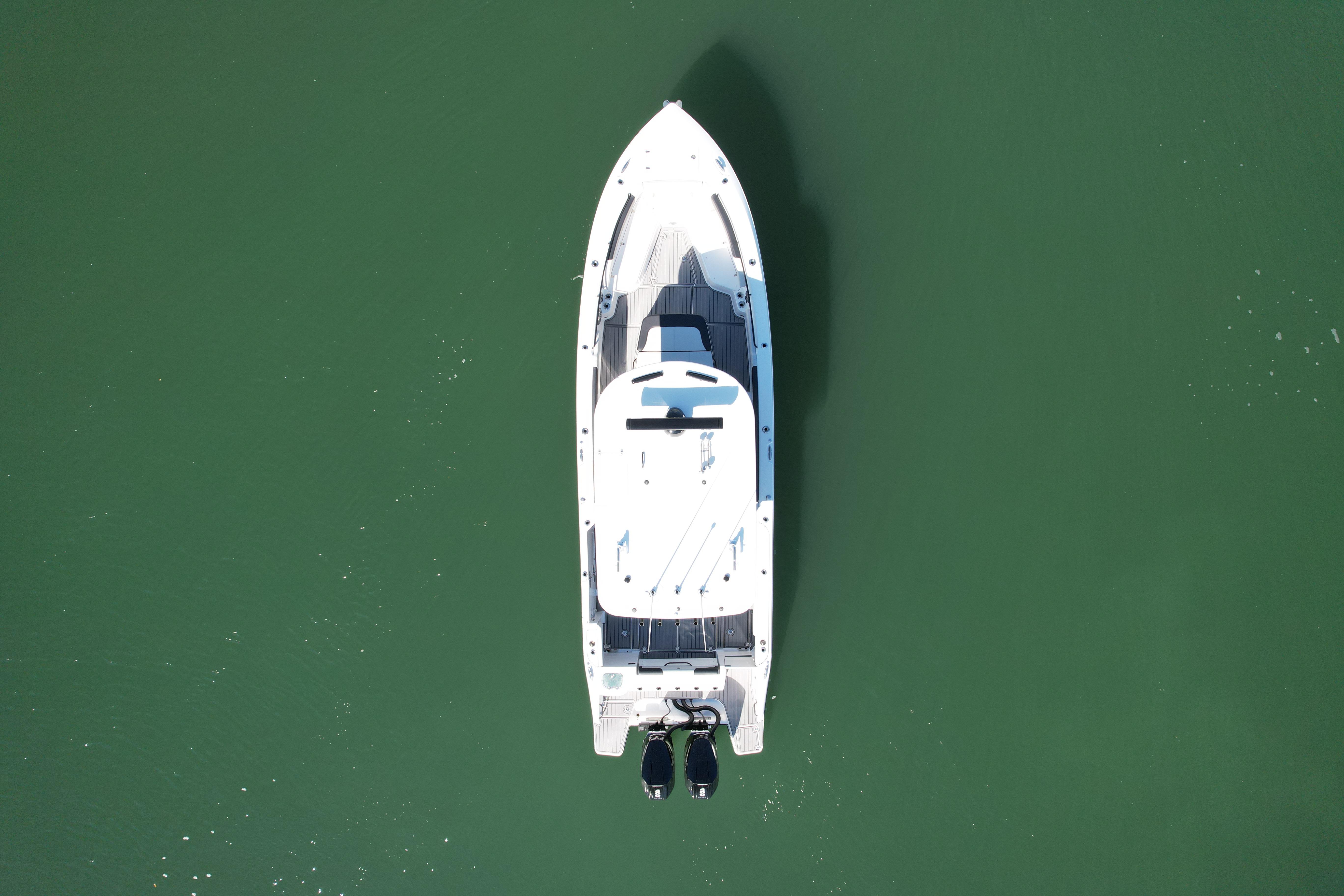 Aerial view of 2026 Edgewater 340CC boat on calm green water.