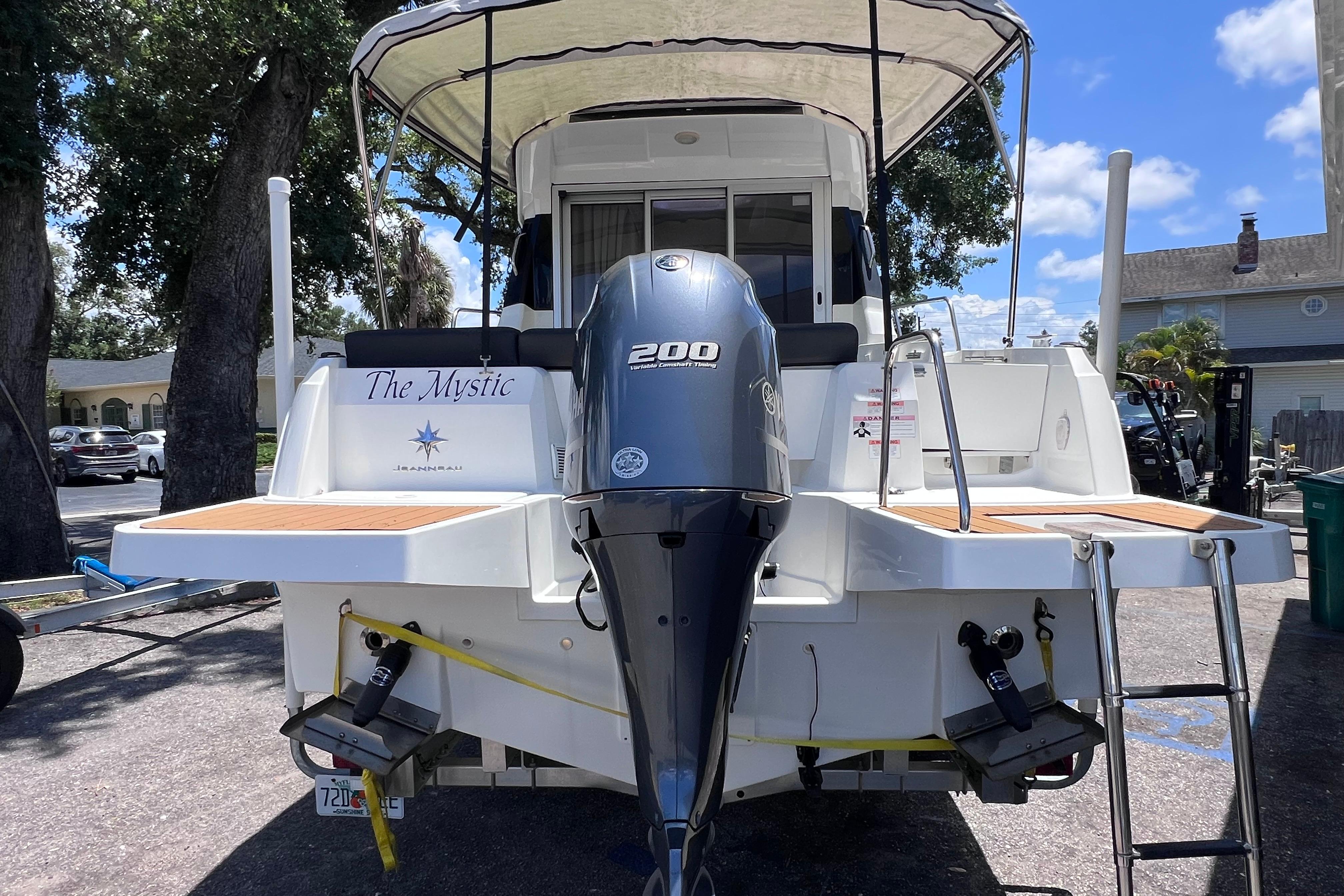 2021 Jeanneau NC Weekender 795 Series 2 boat with outboard motor, docked outdoors.