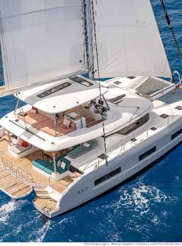 2025 Lagoon 55 catamaran sailing on blue ocean waters, showcasing luxury and modern design.