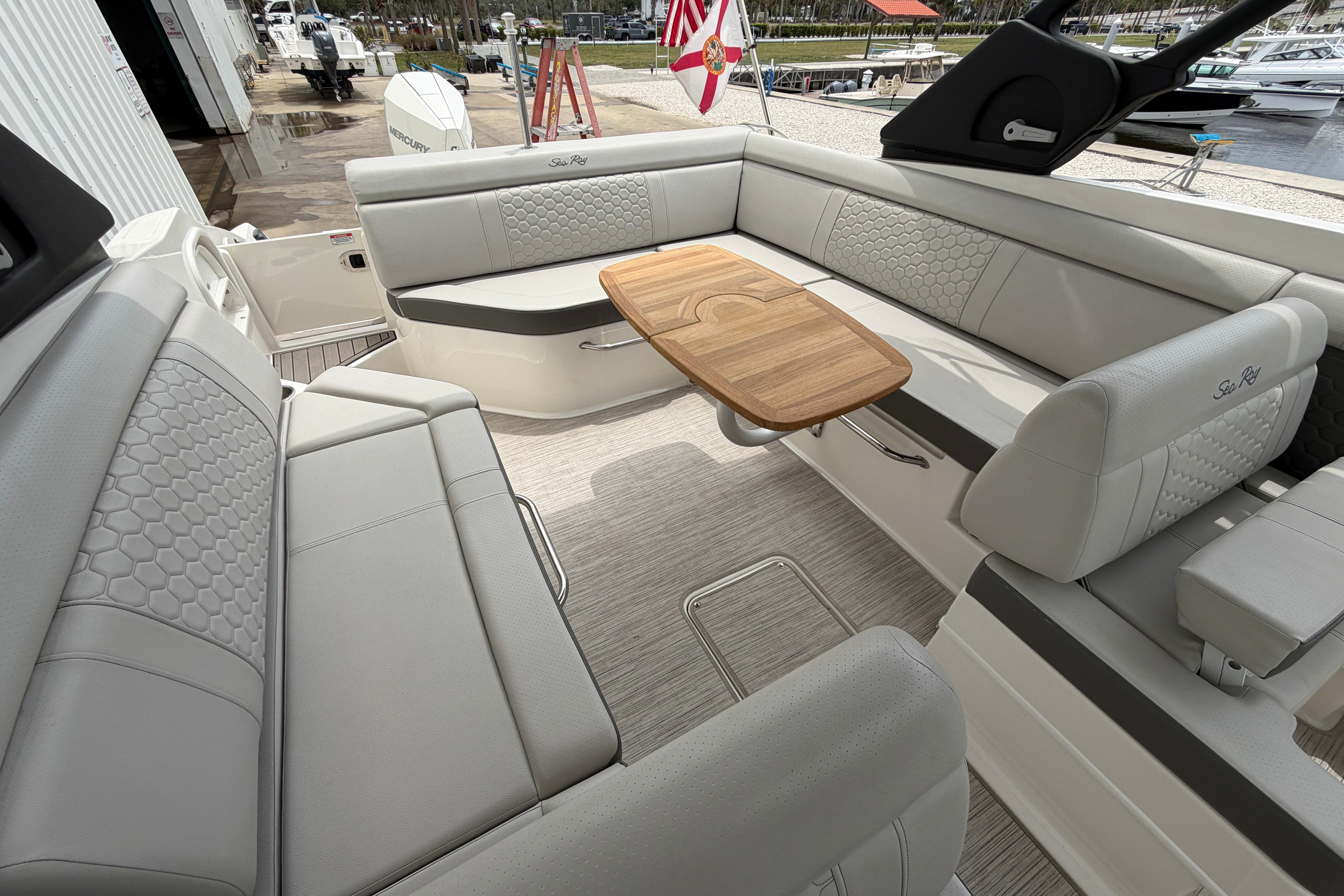 Luxurious interior of 2024 Sea Ray SDX 270 Outboard with elegant seating and wooden table.