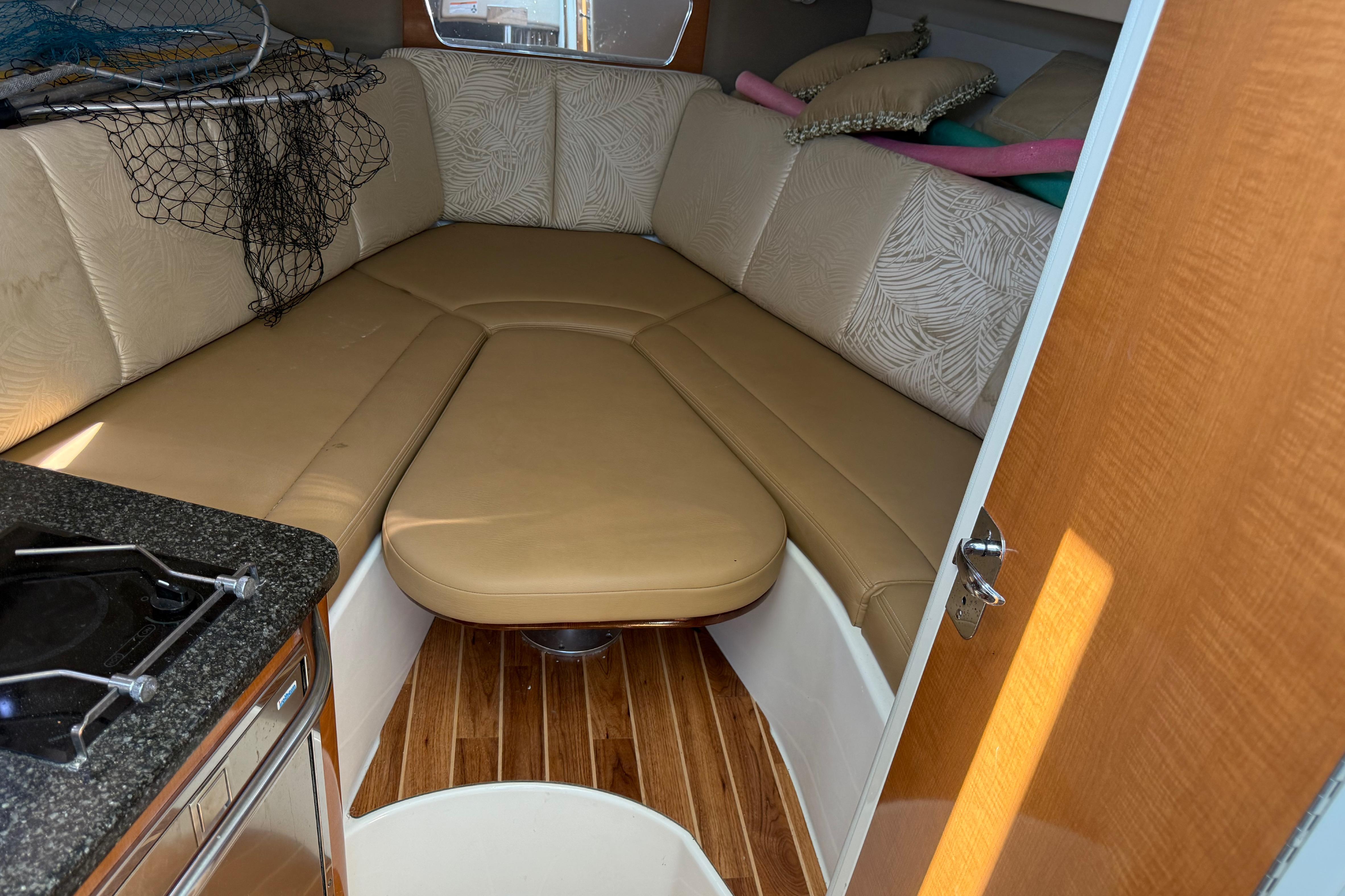 2007 Robalo R305 Walkaround cabin interior with beige seating and wooden flooring.