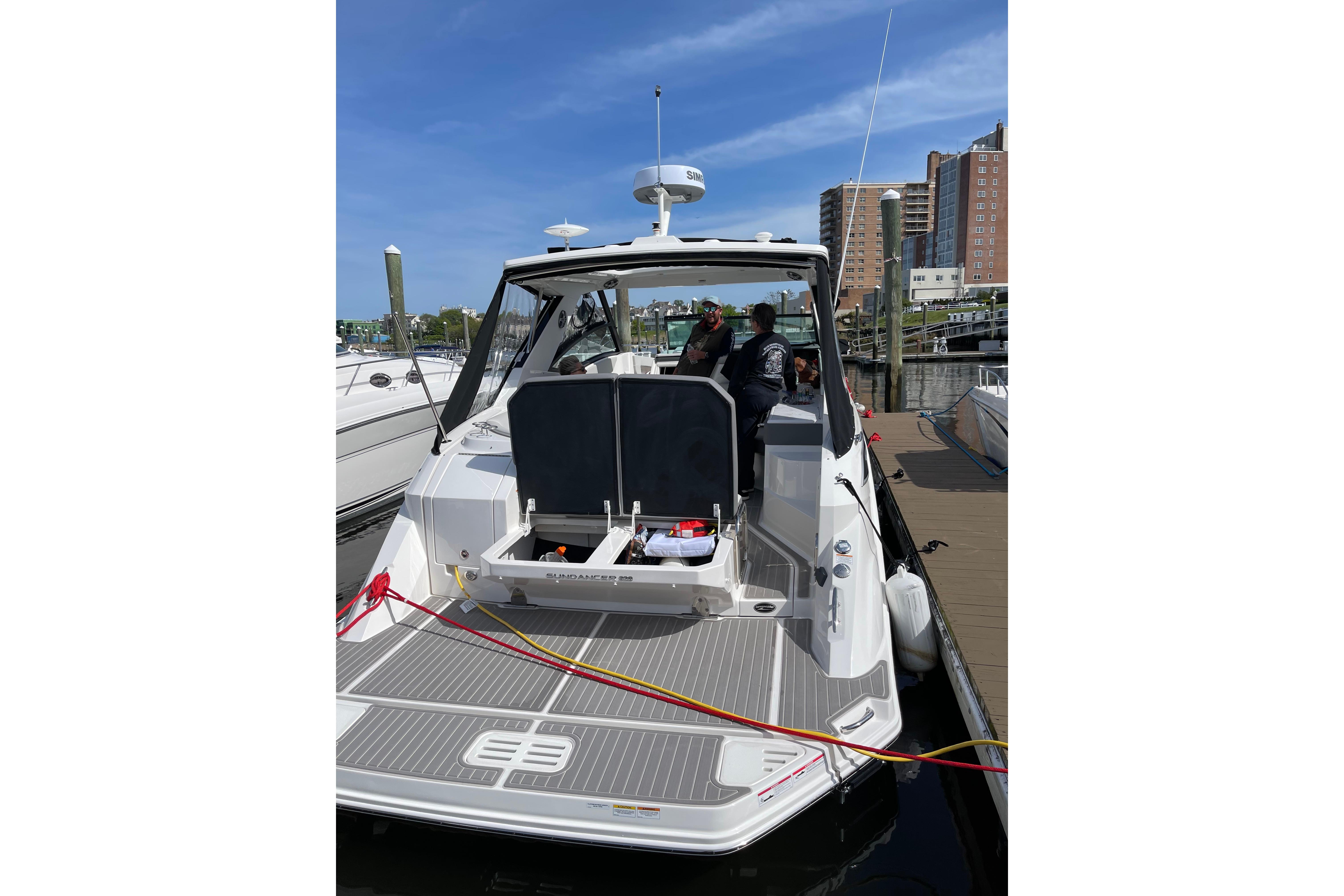 2023 Sea Ray Sundancer 320 docked at marina, showcasing sleek design and spacious deck.