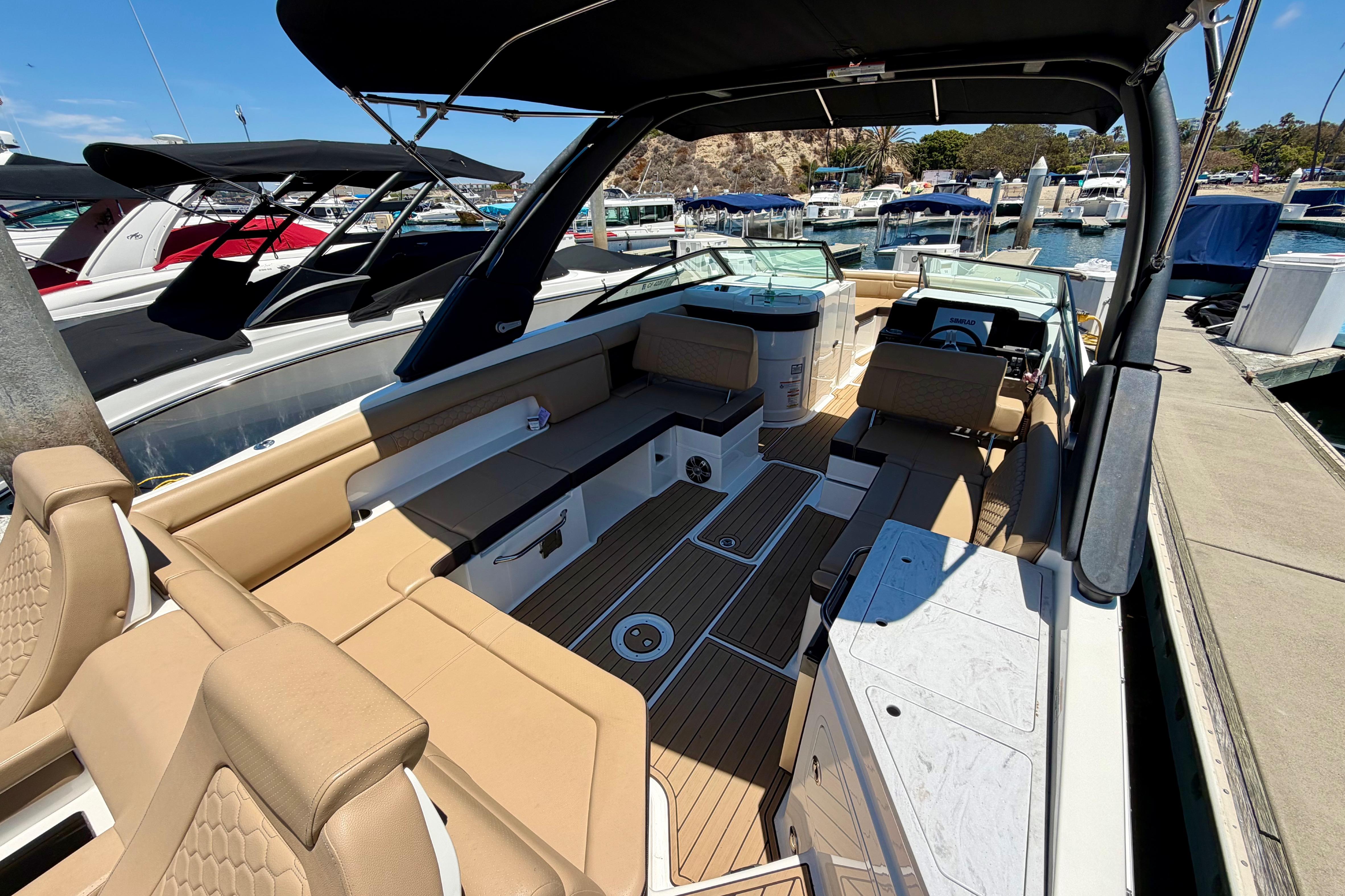 2024 Sea Ray SDX 290 boat interior with tan seating, docked at a marina.