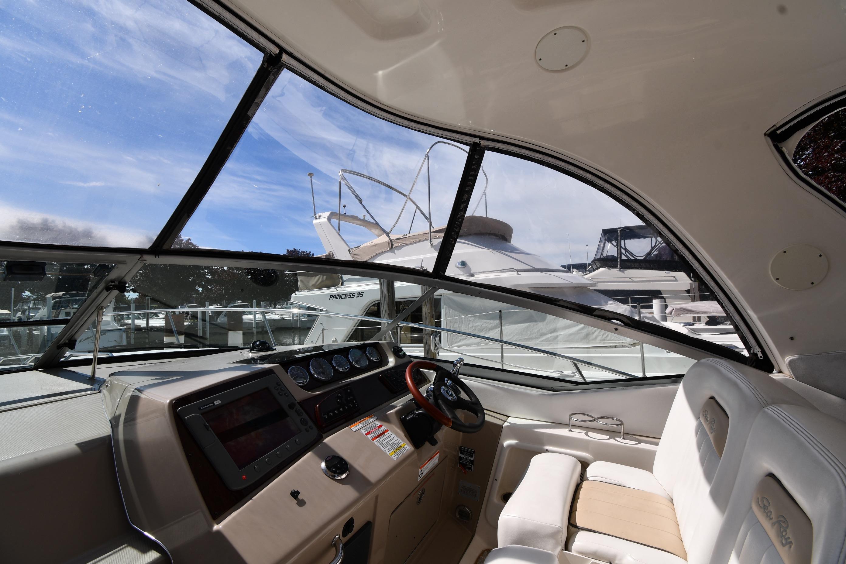 Interior view of a 2008 Sea Ray Sundancer 350 yacht cockpit with steering wheel and dashboard.