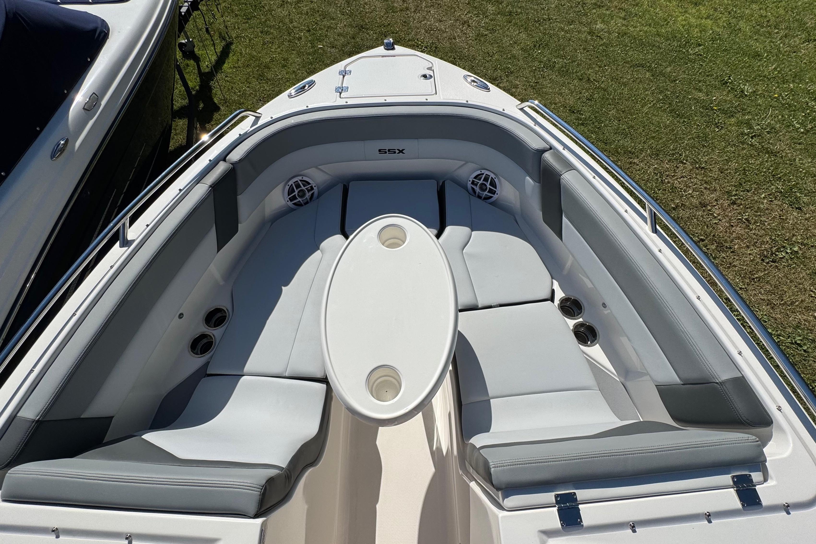2026 Chaparral SSX 4 boat interior with cushioned seating and oval table on grass.