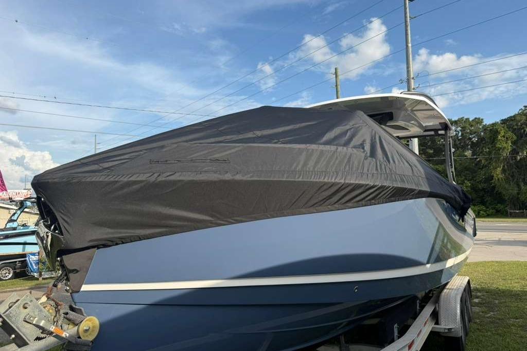 2026 Monterey Elite 30 OB boat covered, parked on a trailer under a clear sky.