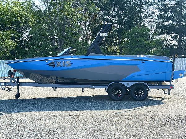 2025 Axis A225 boat in blue and gray on a trailer, parked outdoors.