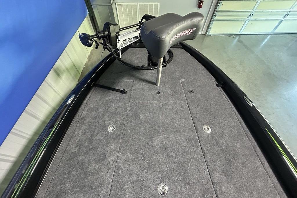 2026 Phoenix 819 ZXL boat deck with seat and trolling motor in a garage.