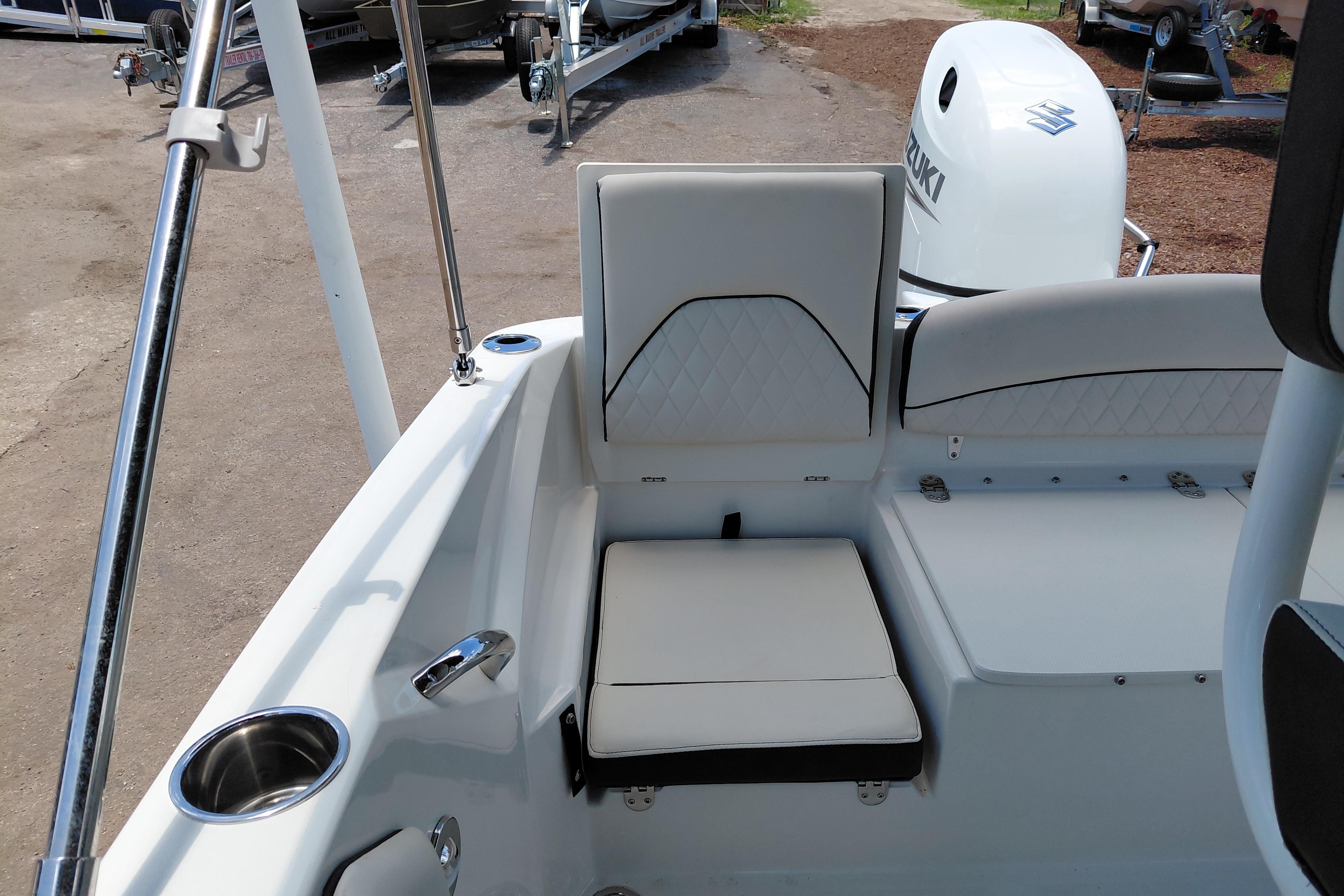 2023 Stingray 206 CC boat interior with white seating and Suzuki outboard motor.