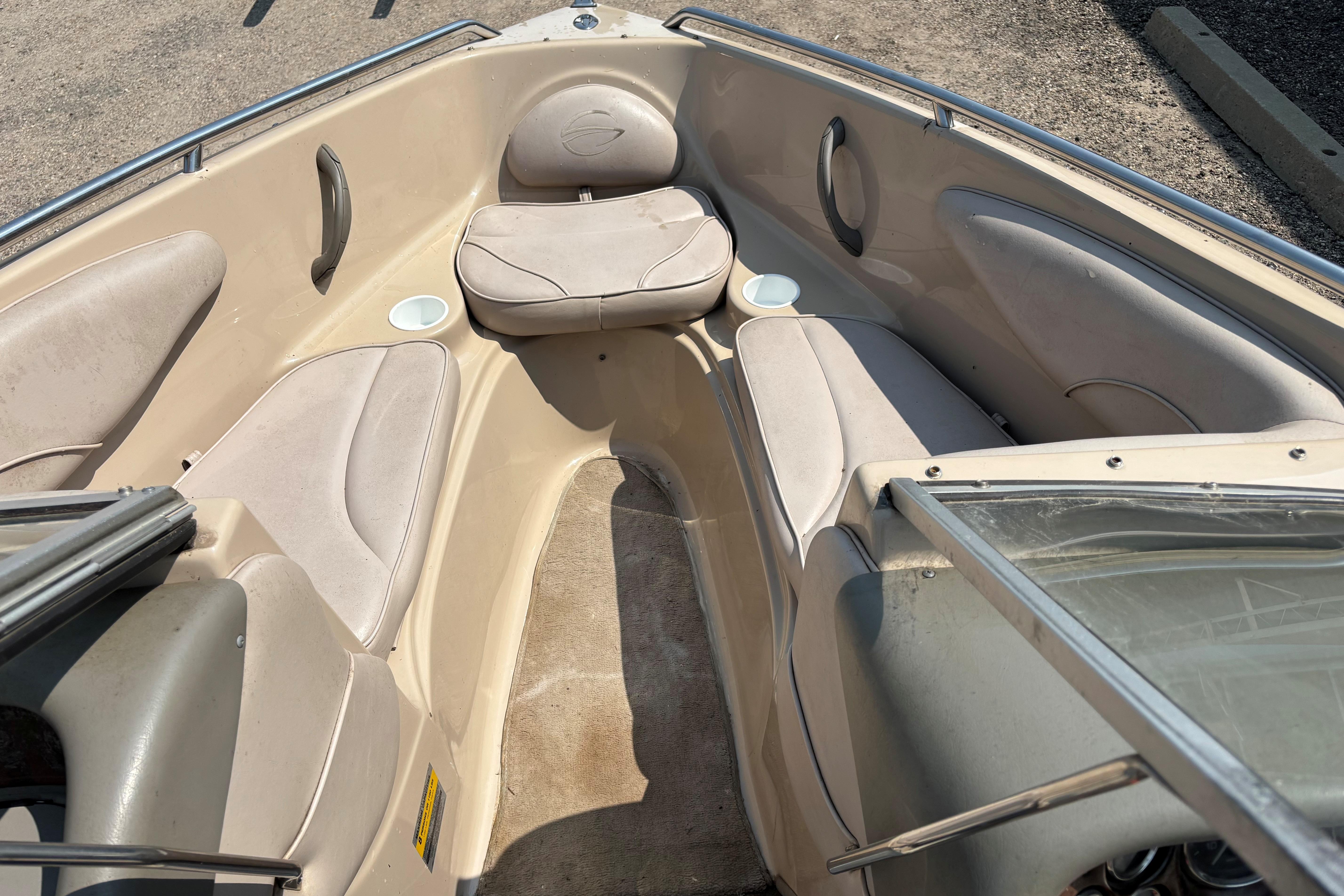 2001 Crownline 18' boat interior with beige seating and cup holders.