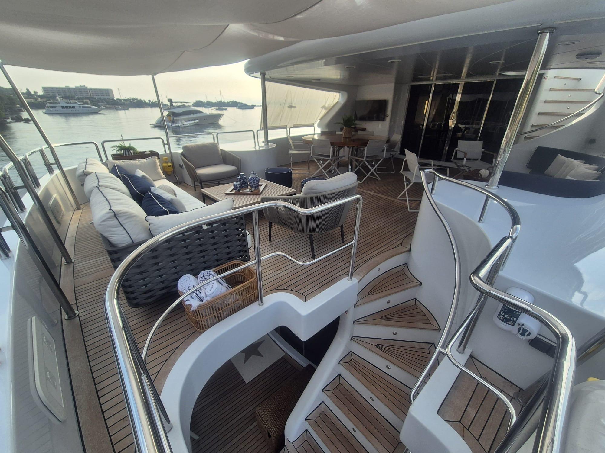 Luxurious Benetti Classic 115 yacht deck with elegant seating, overlooking a serene marina.