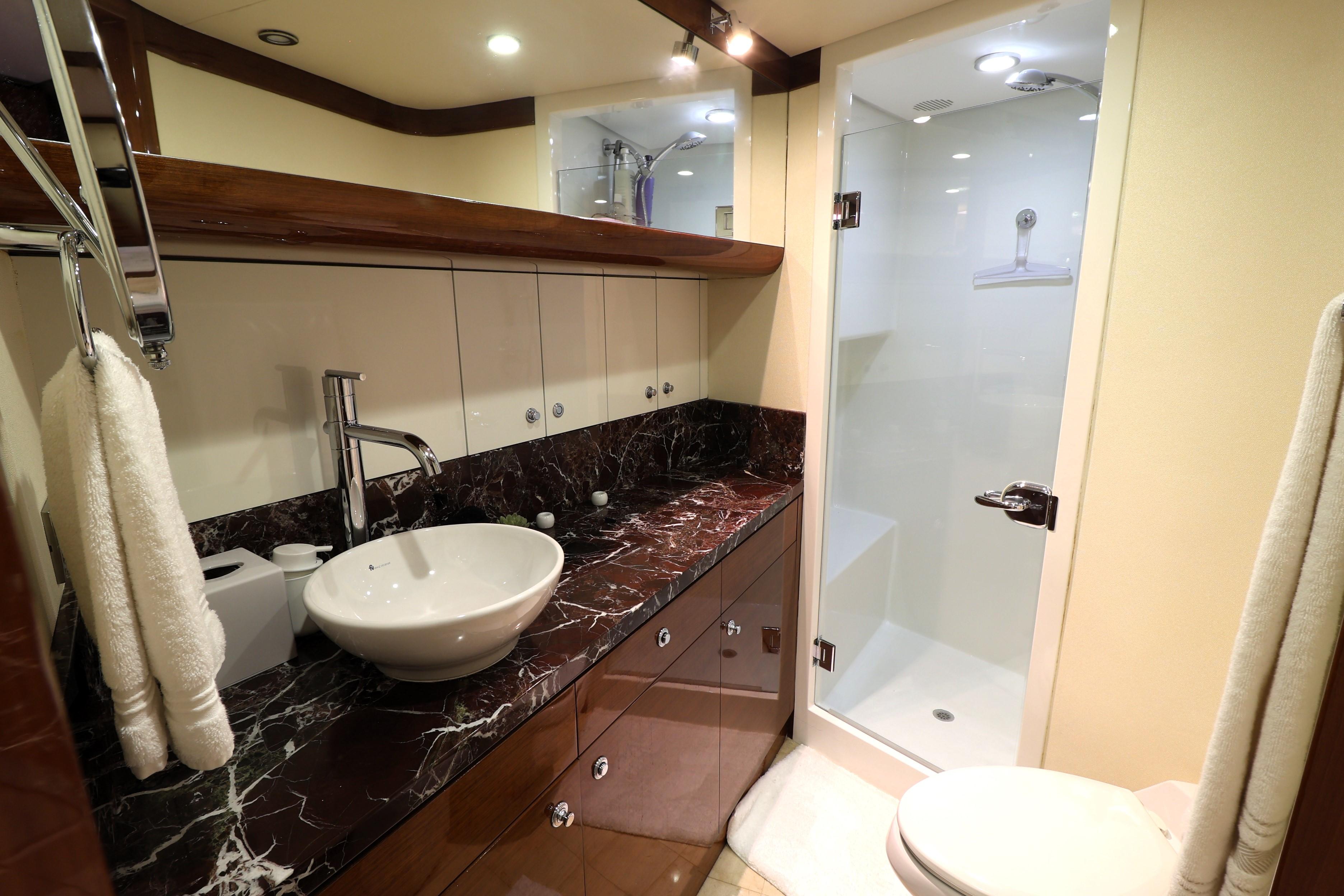 Luxurious bathroom in 2013 Cheoy Lee Bravo yacht with marble countertop and modern fixtures.