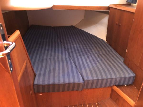 Cozy cabin interior of 2001 Jeanneau 45.2 sailboat with striped bedding.