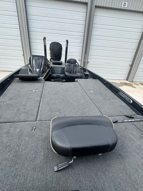 The image shows the deck of a 2023 Skeeter FXR21 Apex boat in a garage.