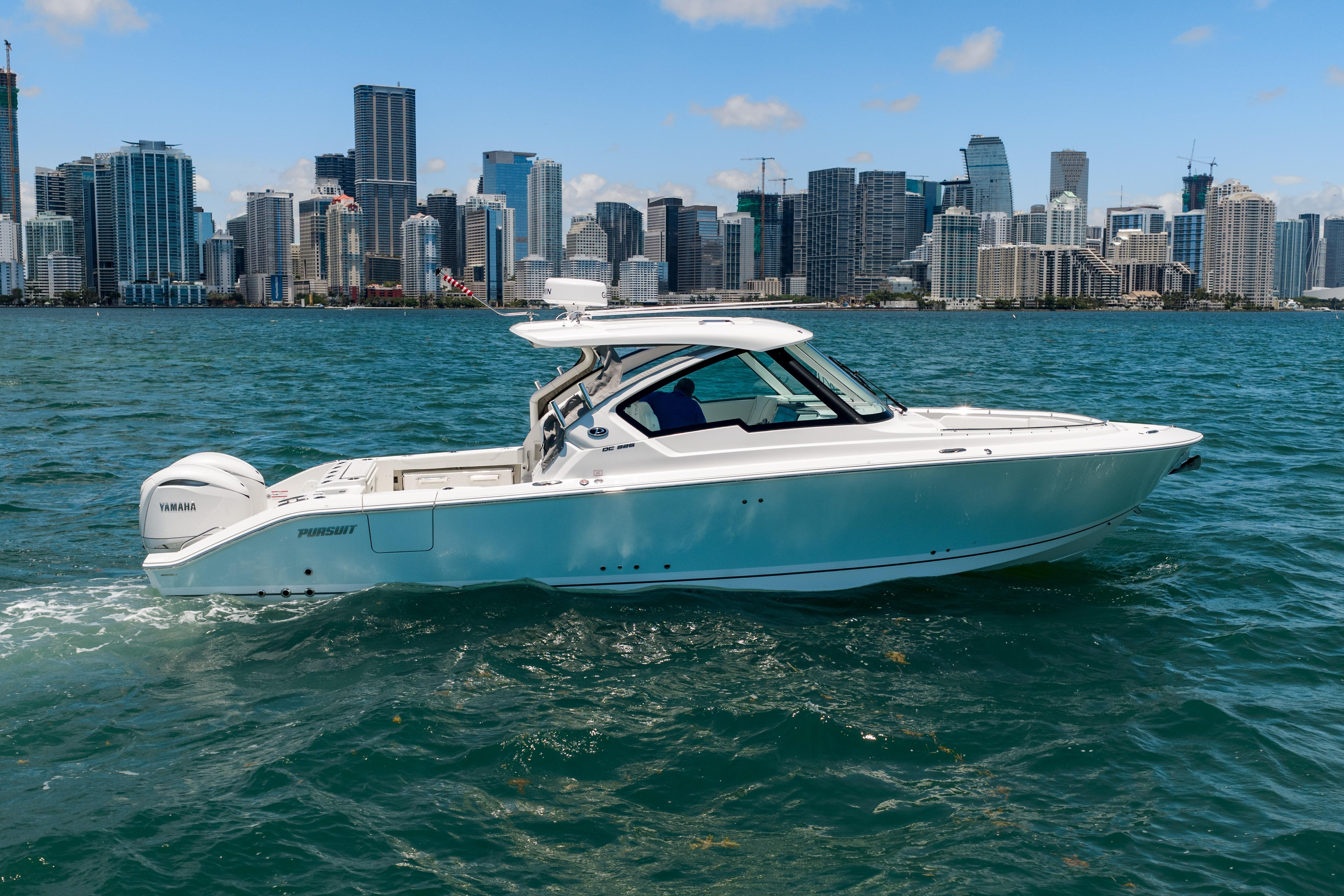 2026 Pursuit DC 326 Dual Console boat cruising near city skyline.
