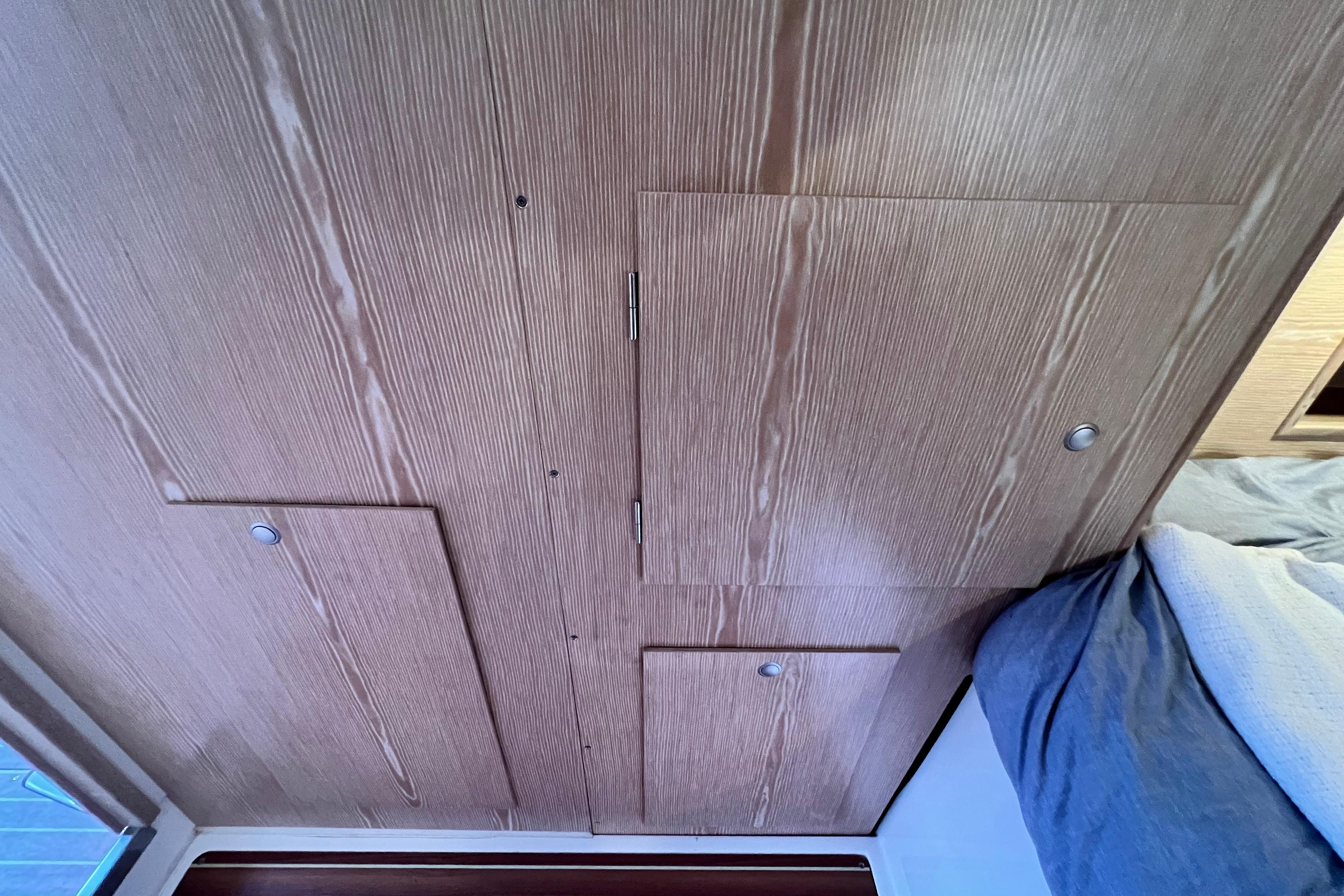 Wooden interior paneling with storage compartments in a 2016 Hanse 455 yacht cabin.
