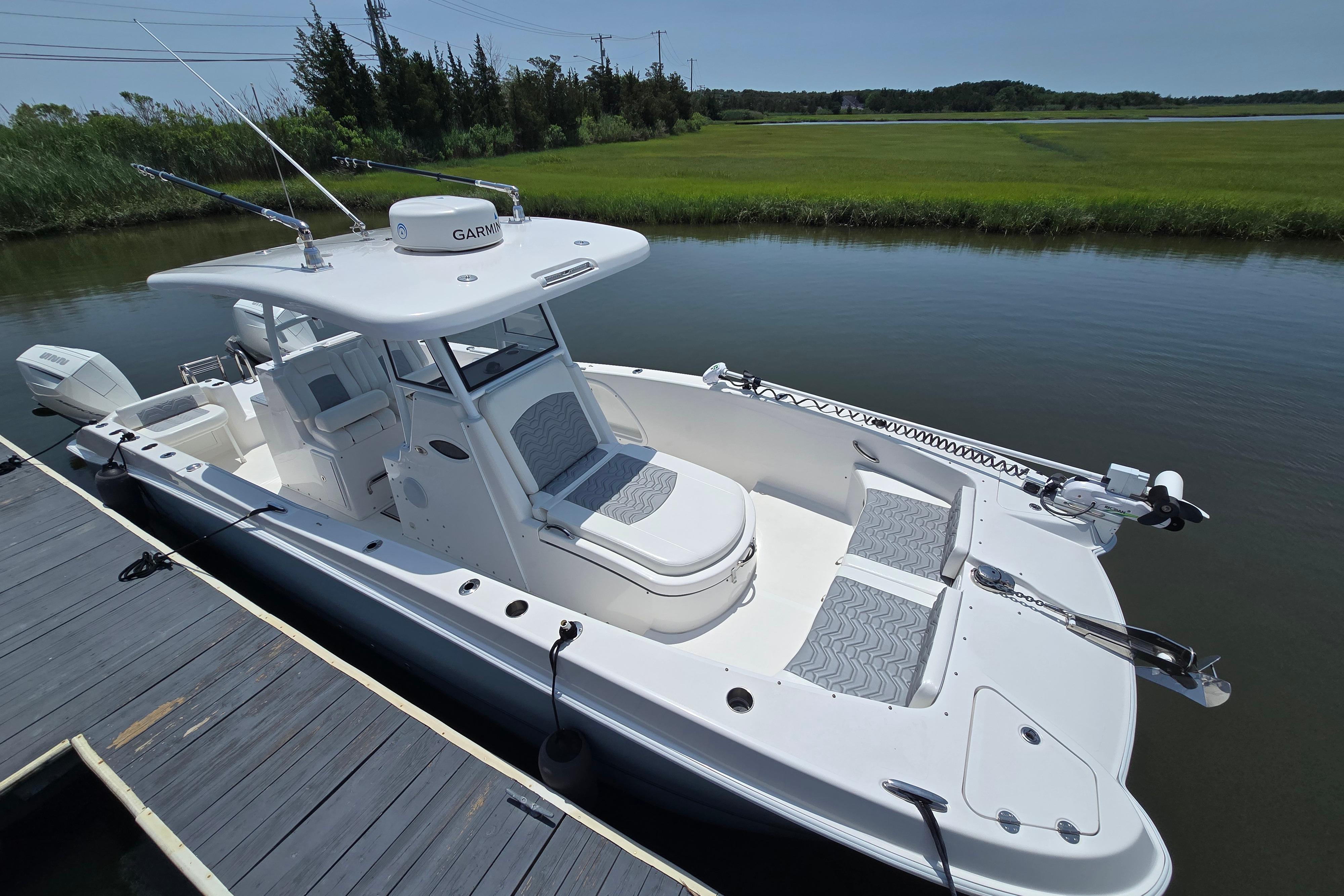 2021 Twin Vee 280 GFX CC boat docked on calm water, featuring sleek design and modern equipment.