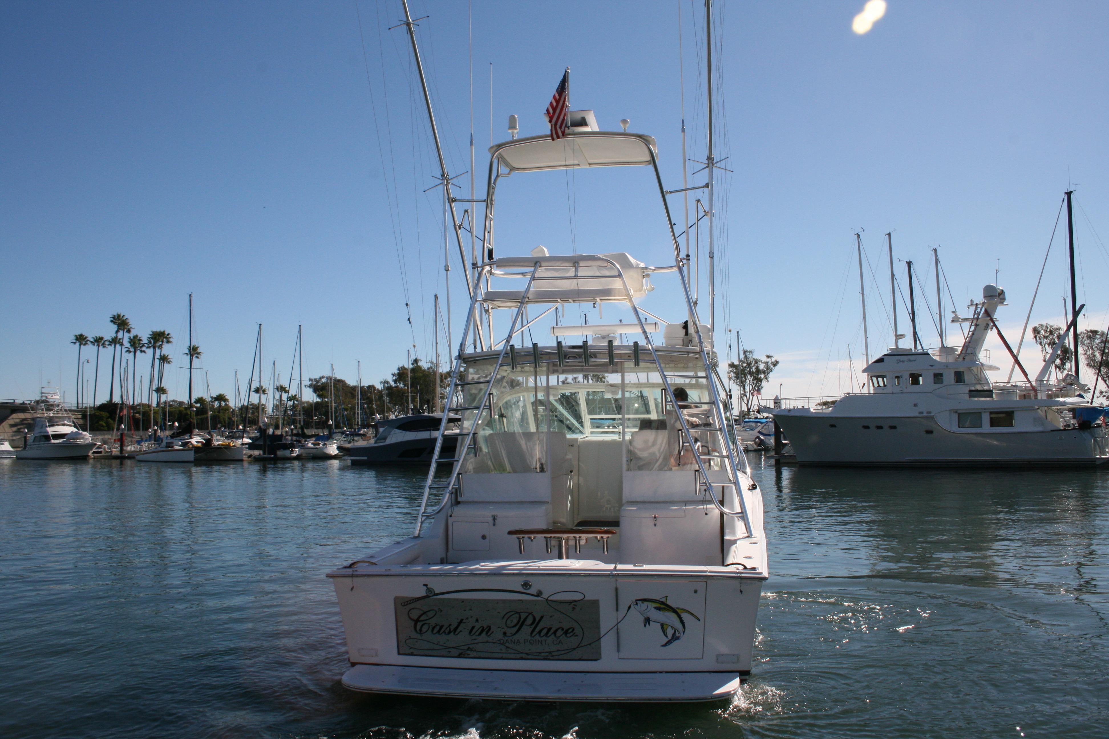 2005 Cabo 35 Express boat docked in a marina under clear blue skies.