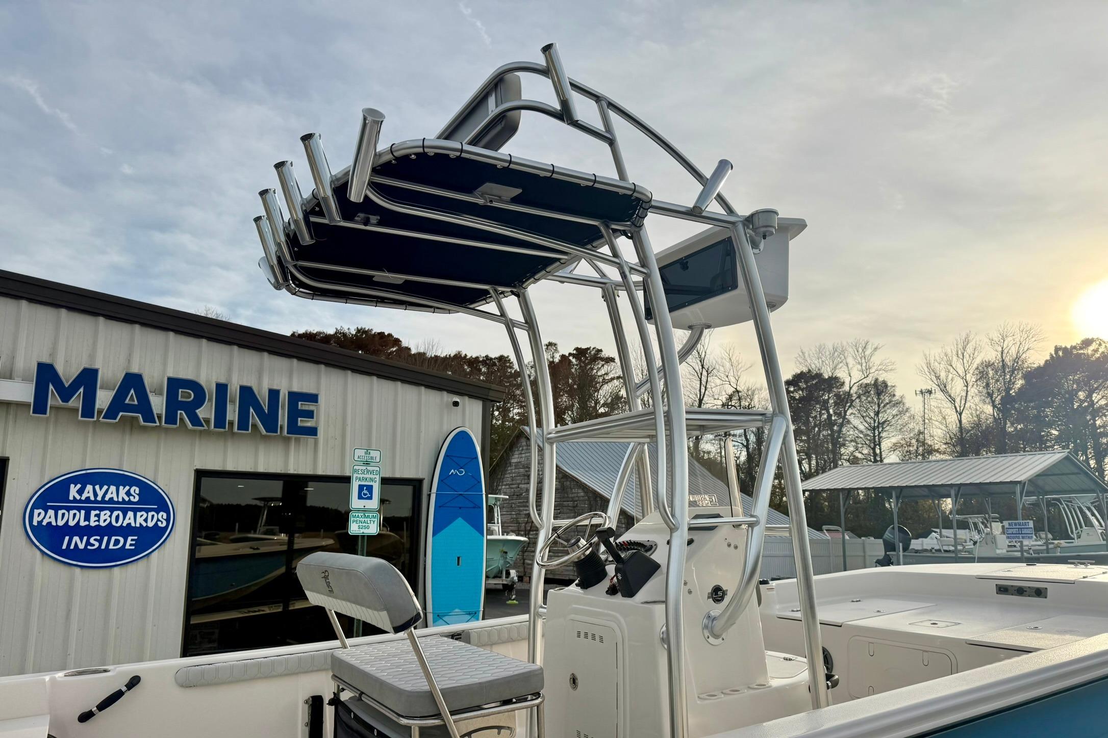 2025 Carolina Skiff 21 LS boat at marine dealership with kayak and paddleboard signage.
