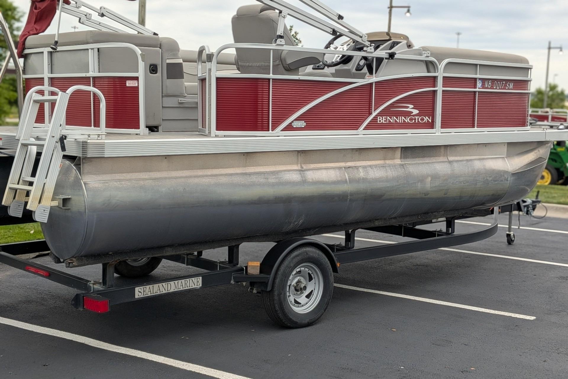 2021 Bennington 205SL pontoon boat on trailer in parking lot.
