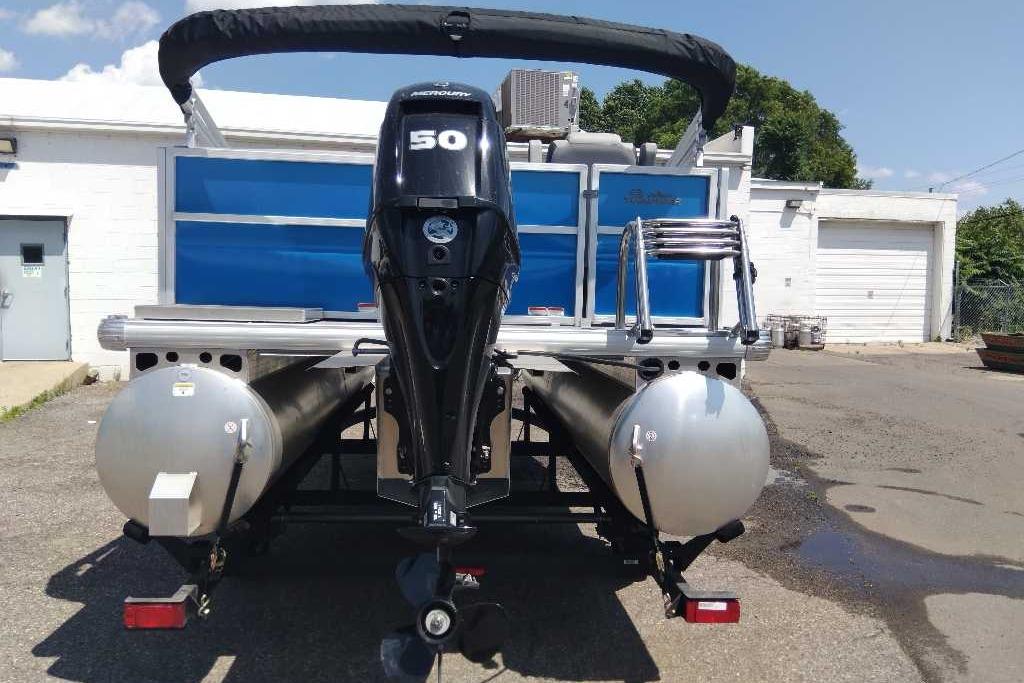 2026 Sun Tracker Party Barge 16 DLX pontoon boat with Mercury 50 engine, parked outdoors.