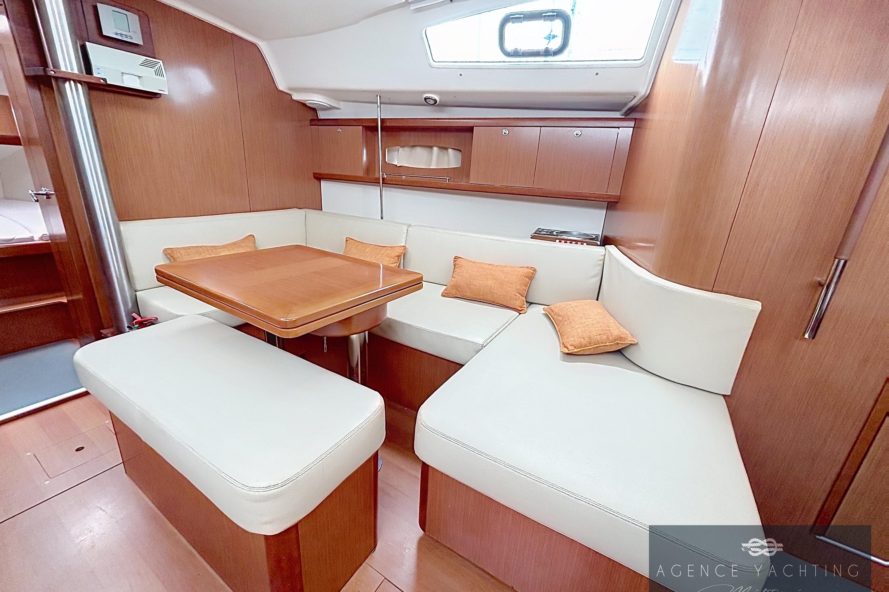 Interior of 2008 Beneteau Oceanis 40 yacht with cozy seating and wooden table.