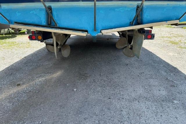 1980 Chris-Craft 381 Catalina boat underside with dual propellers on gravel surface.