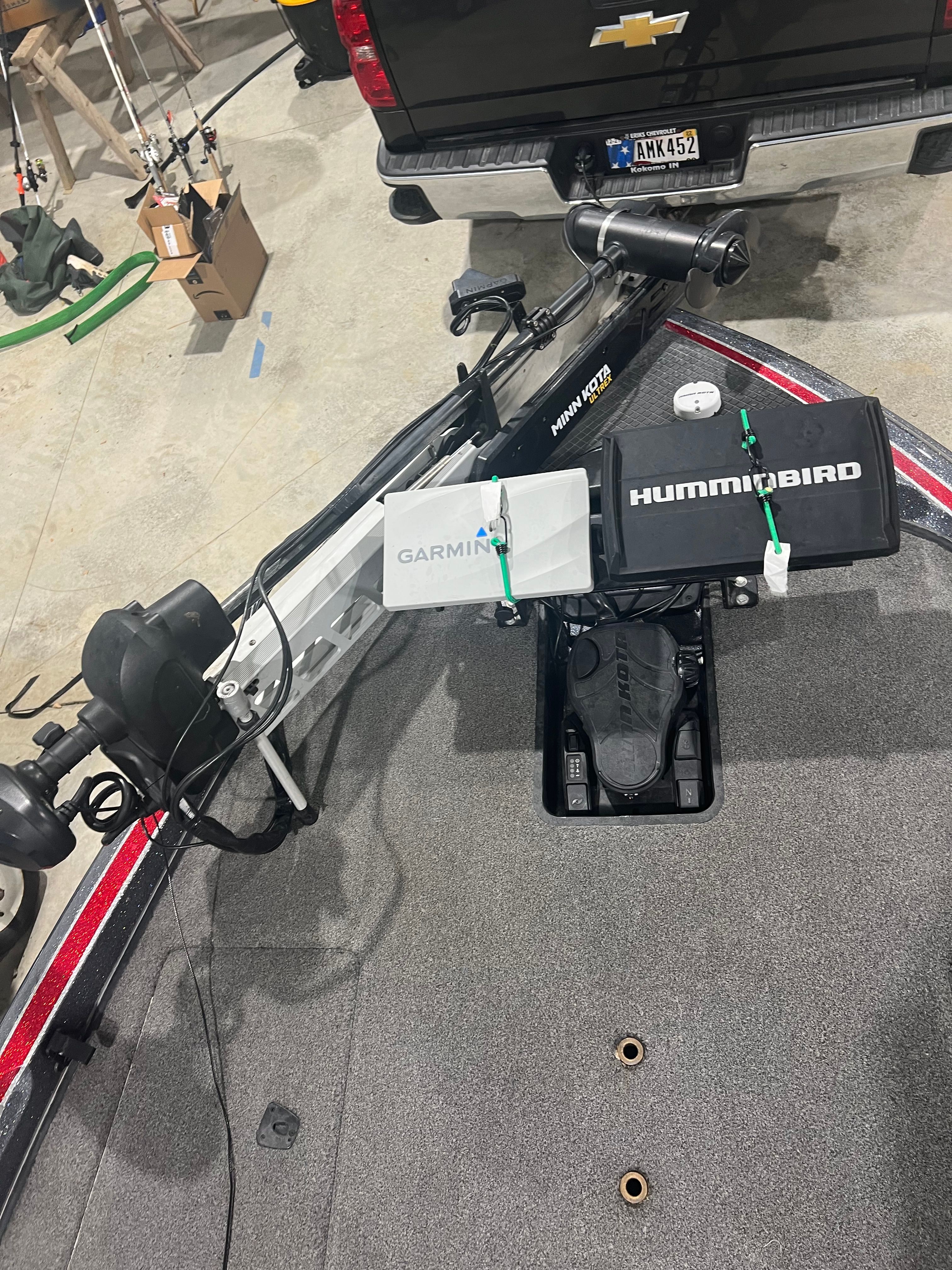 The image shows the deck of a 2015 Triton 18XS boat with Garmin and Humminbird electronics.