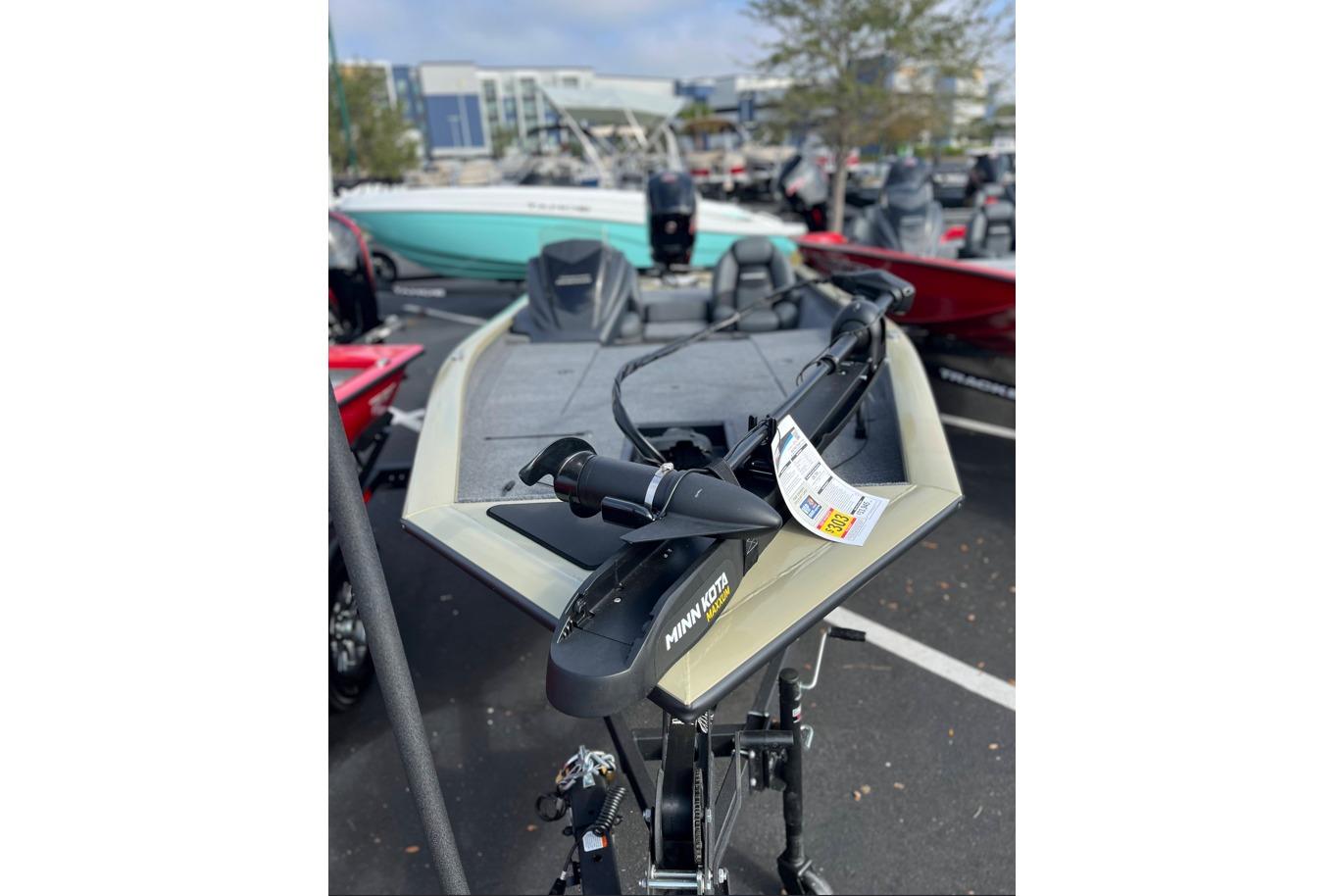 2026 Tracker Pro Team 190 boat with Minn Kota trolling motor in a parking lot.