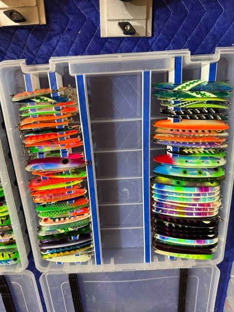 An open tackle box with colorful fishing lures in various shapes and colors.