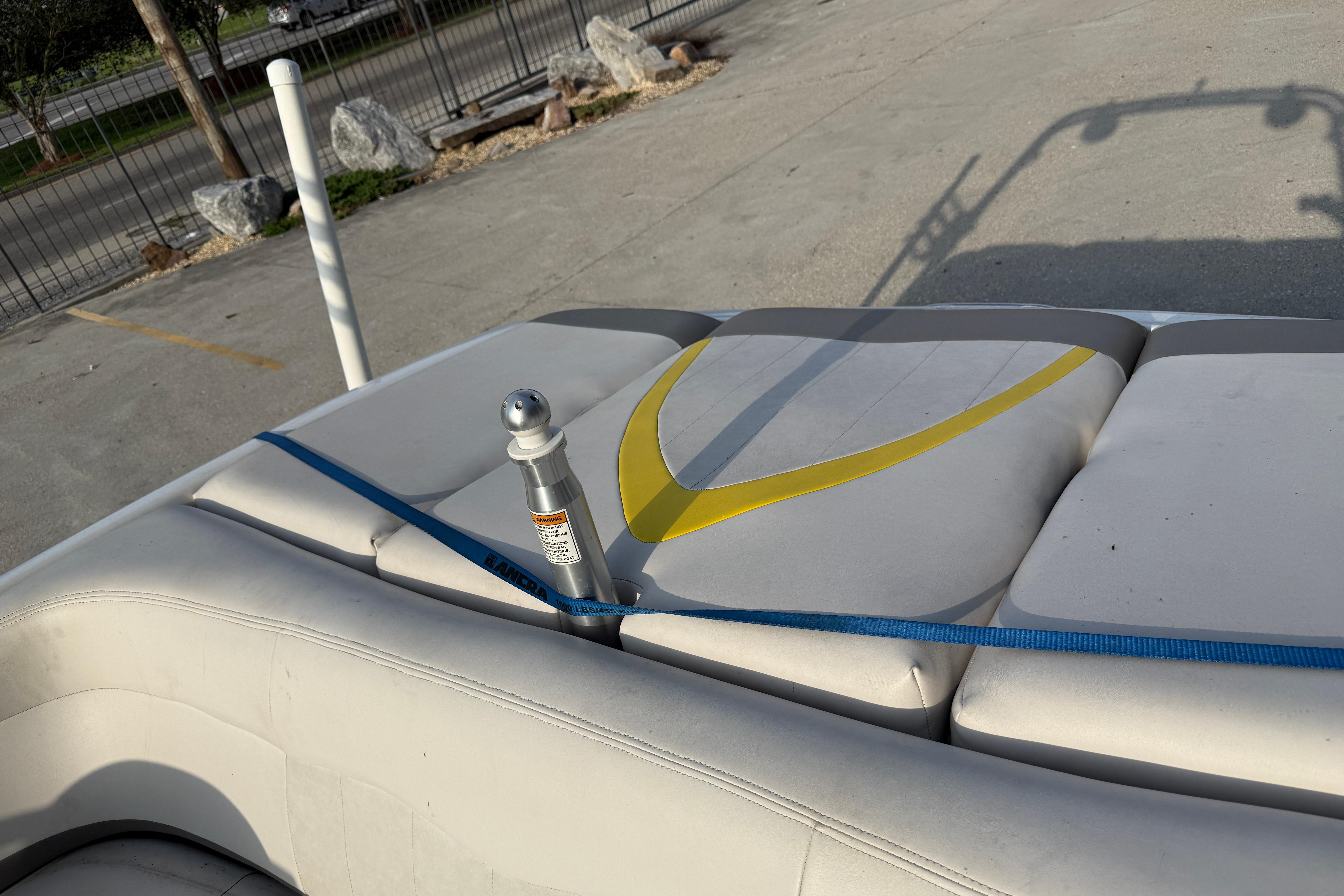 2005 MasterCraft X10 boat interior with white and yellow seating, secured by a blue strap.
