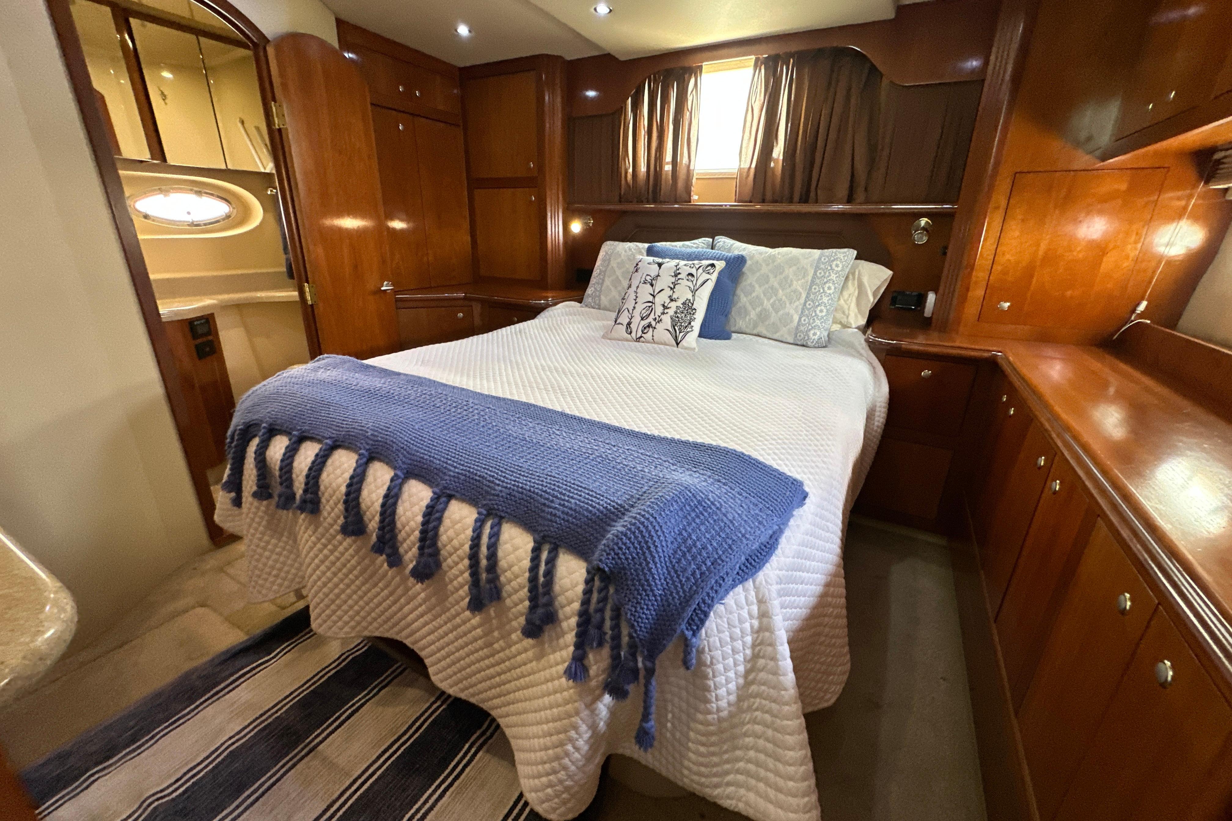 Luxurious bedroom in 2004 Cruisers Yachts 405 Express Motoryacht with elegant wood cabinetry.