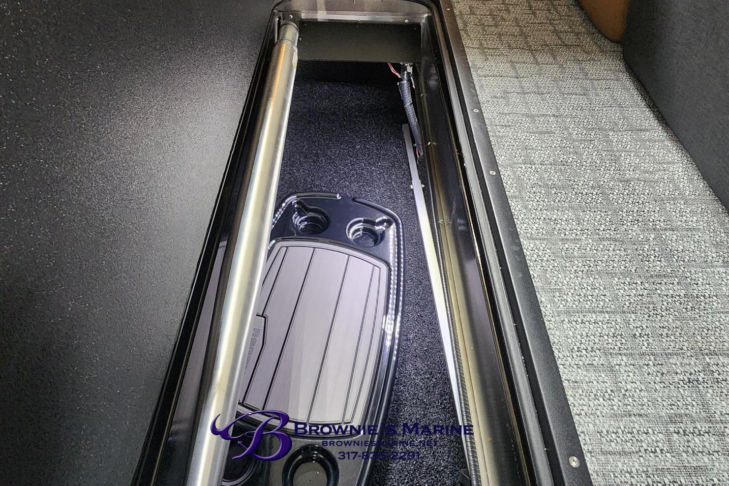 Interior storage compartment of 2026 Regency 250 DL boat, featuring carpeted flooring.
