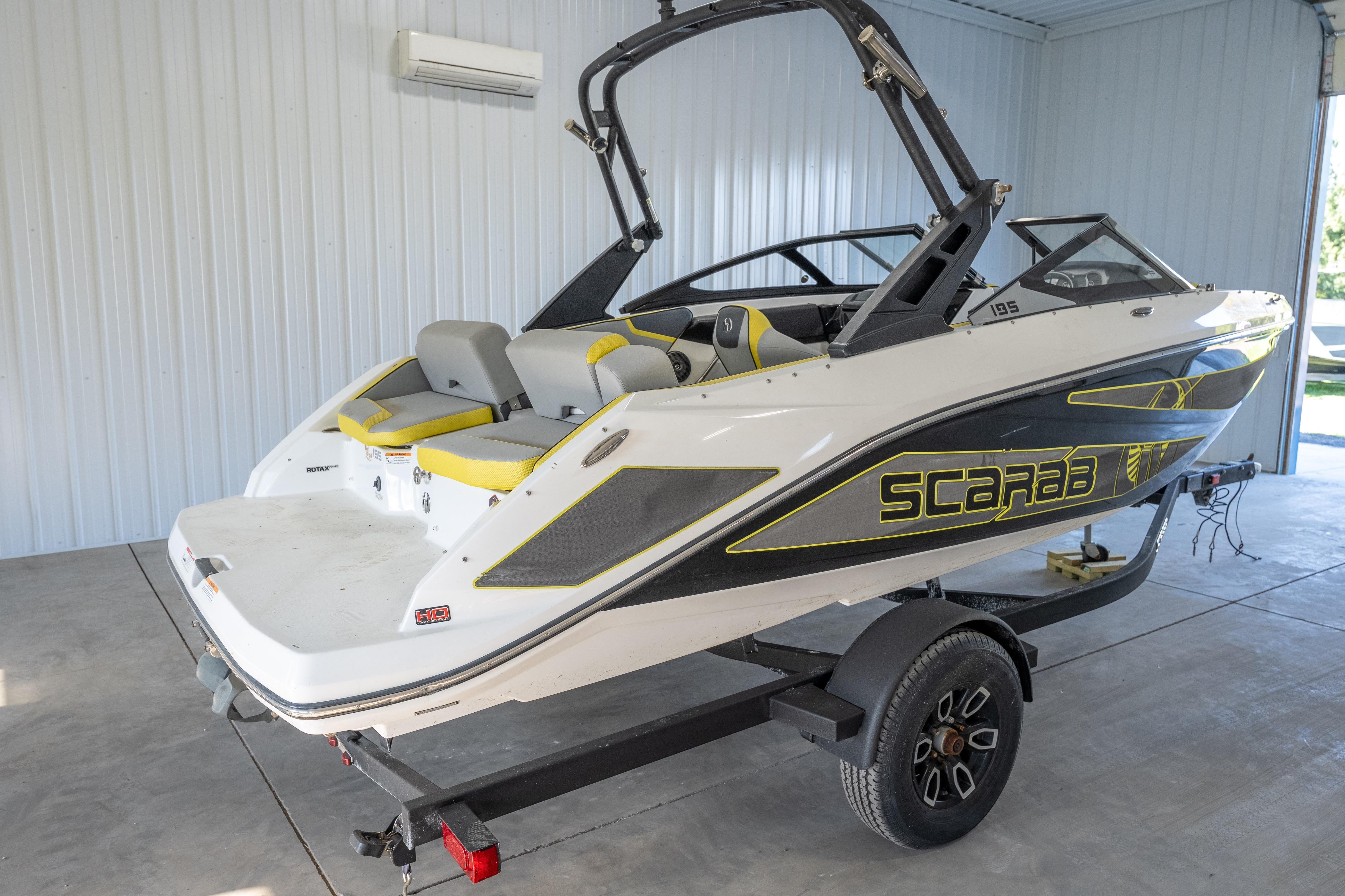 2023 Scarab 195 ID boat in a garage, featuring sleek design and vibrant accents.