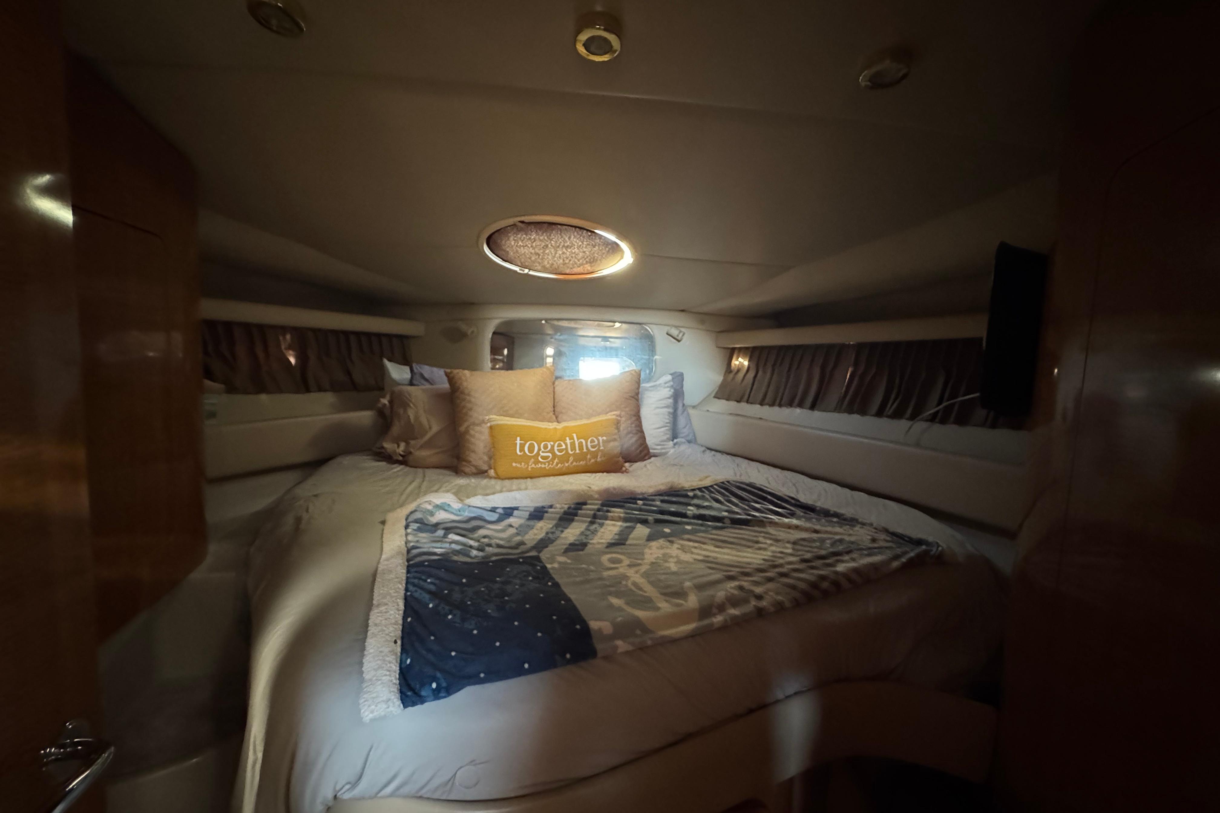 Luxurious cabin interior of 2007 Regal Commodore 3860 yacht with cozy bedding.