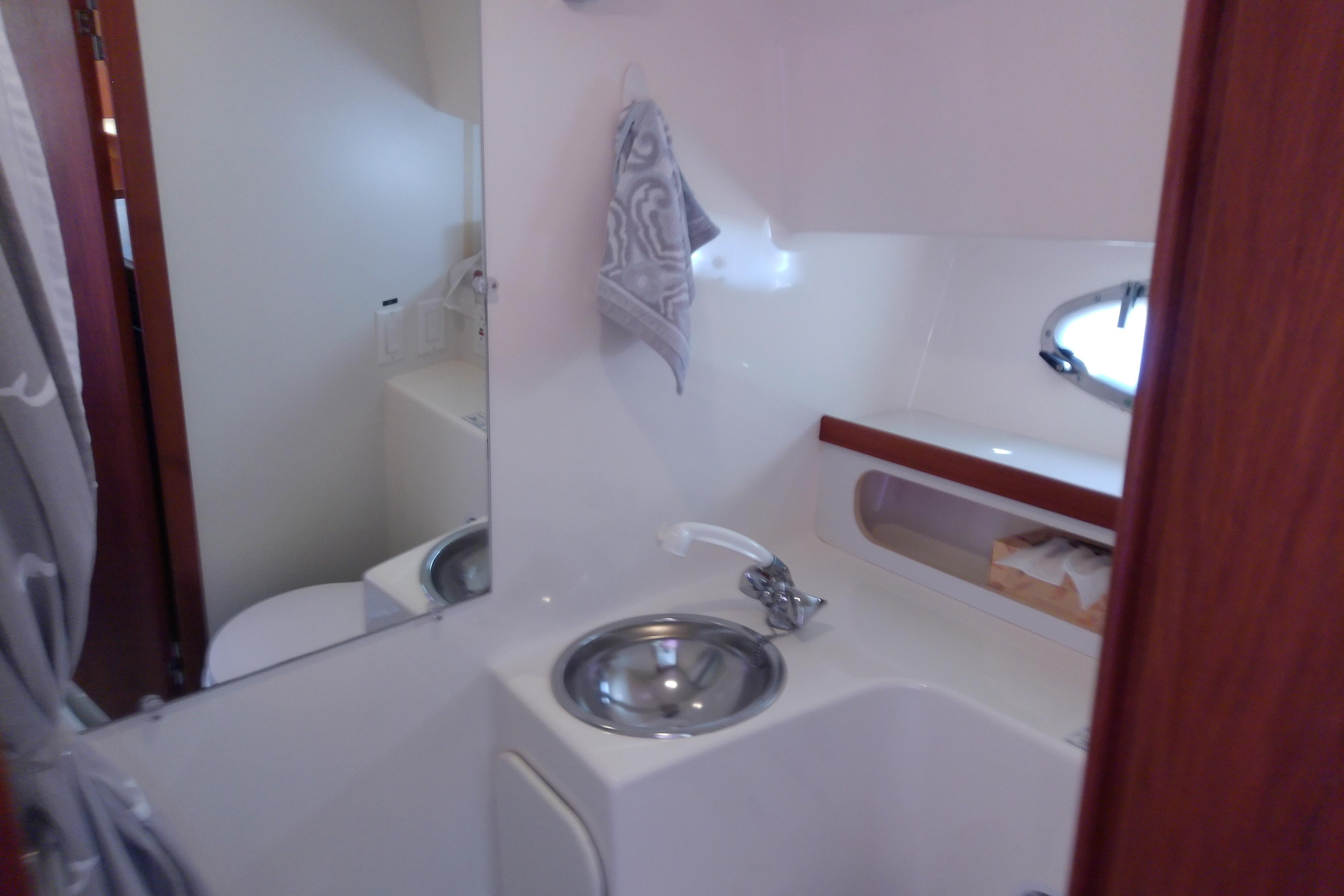 Bathroom interior of 2000 Tiara Yachts 3100 Open, featuring sink and mirror.